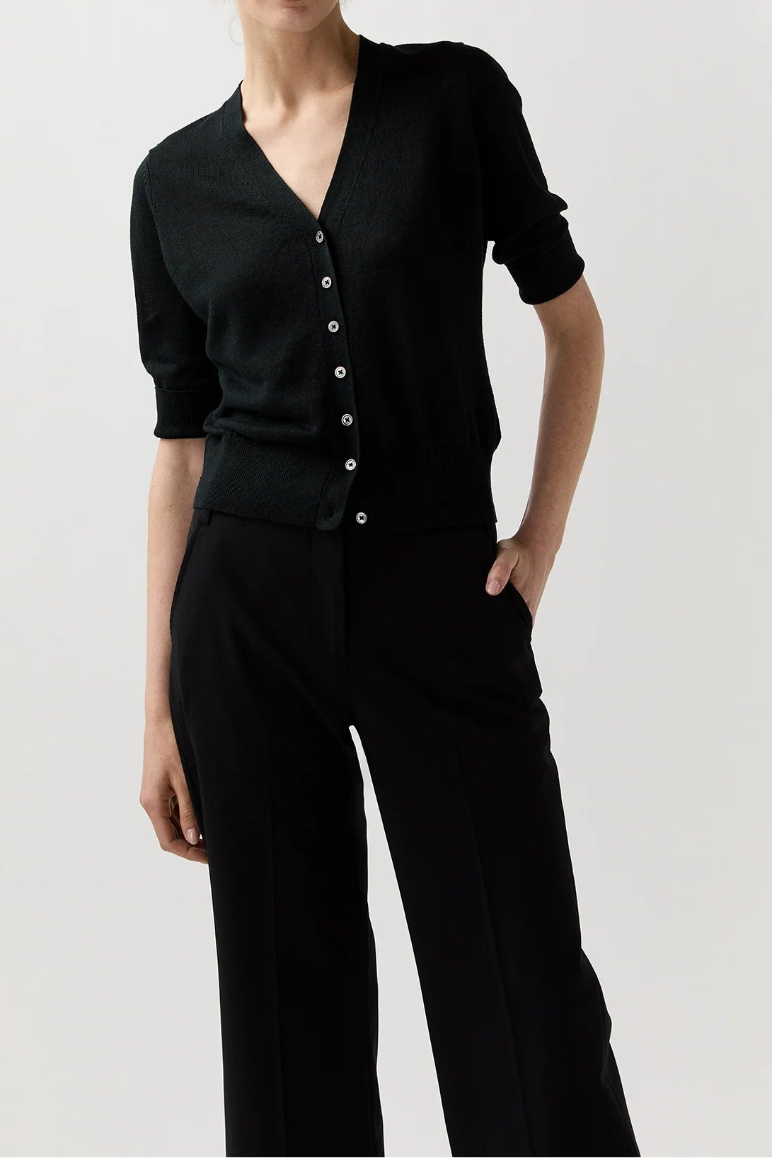 Woman wearing a black outfit with a plain background