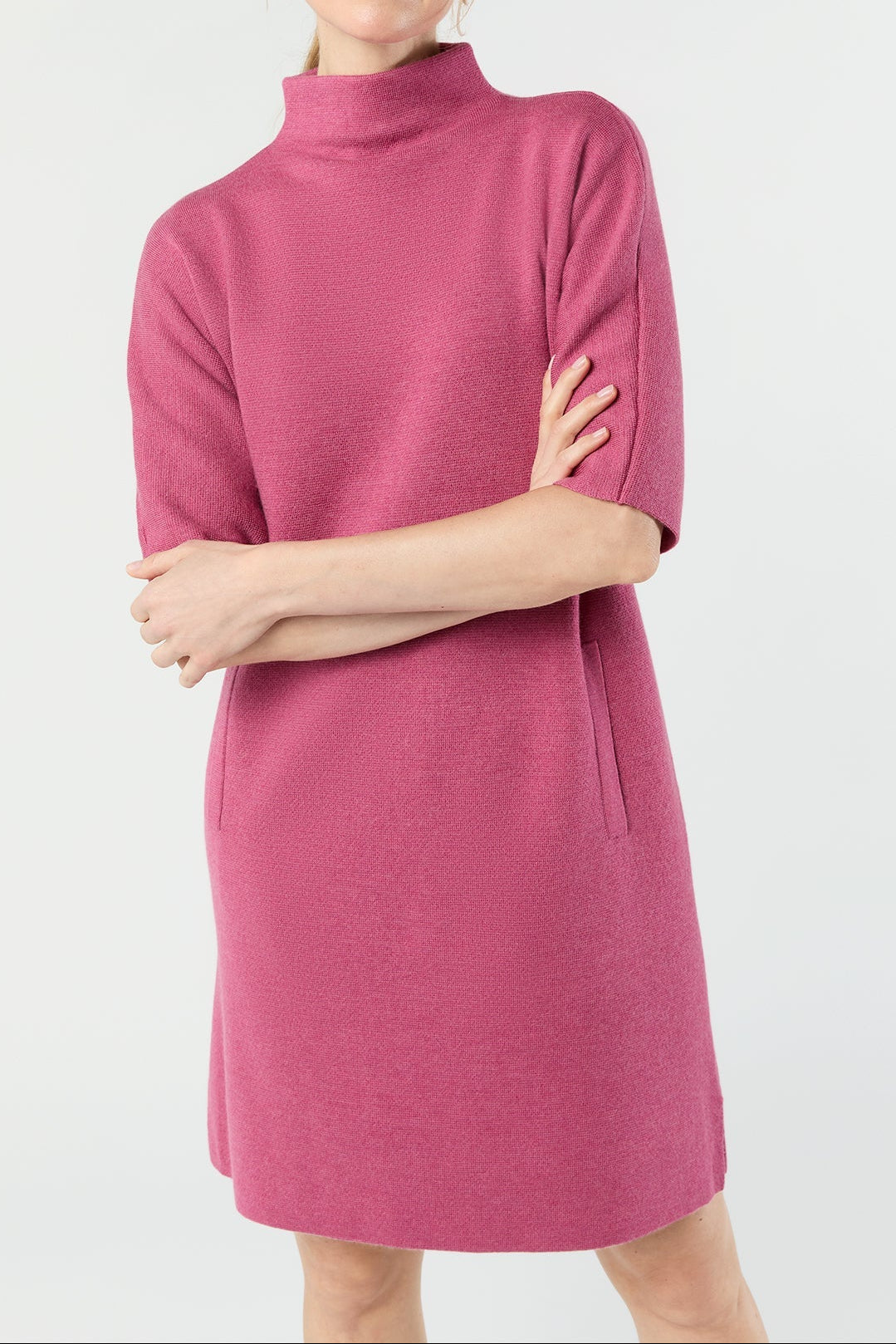 Woman wearing a pink knit dress with a white background
