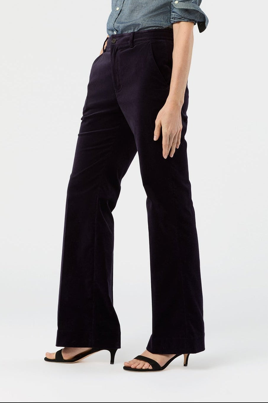 Woman wearing a blue shirt and black pants on a white background