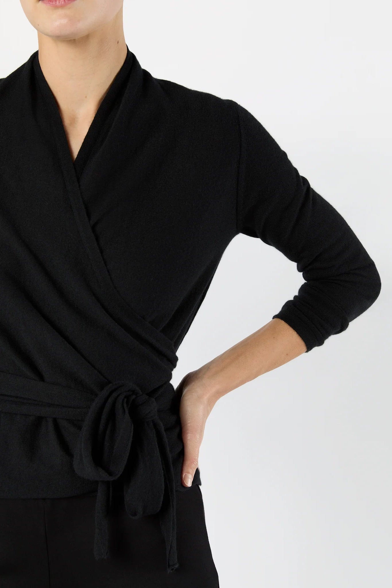 Black wrap dress worn by a person on a white background