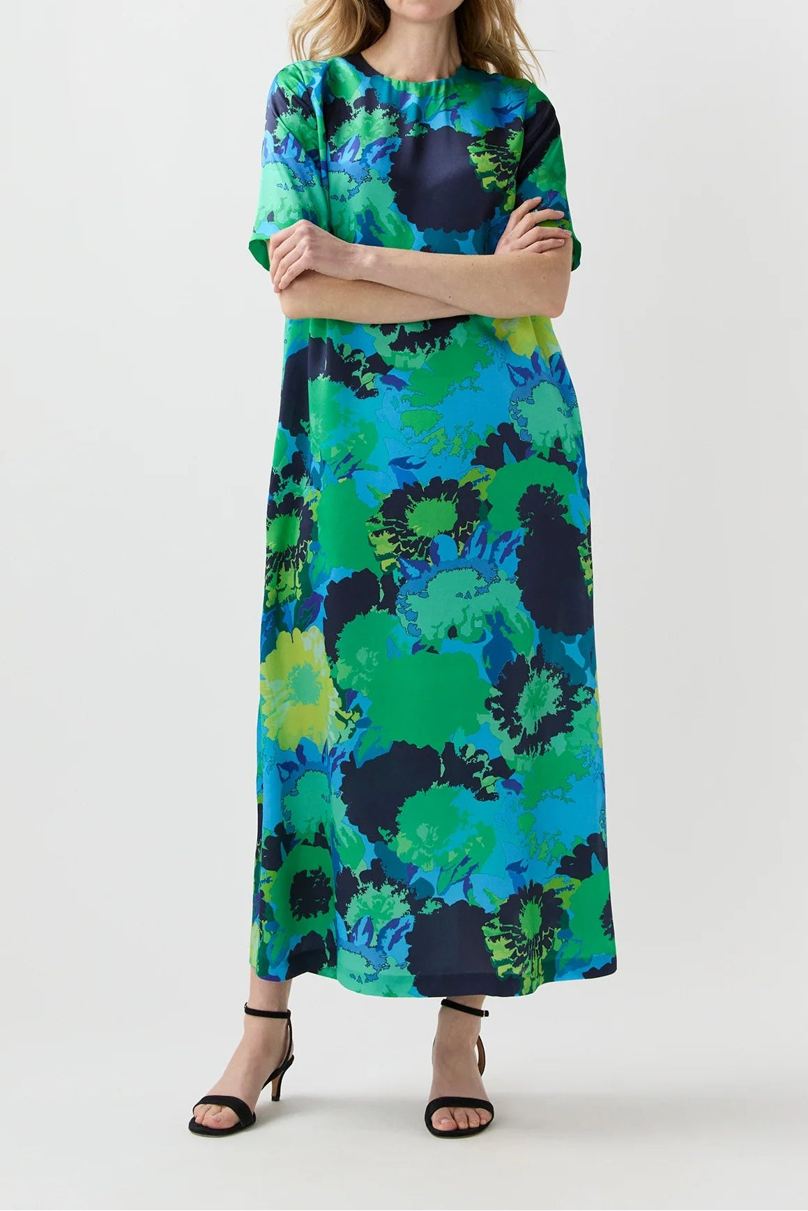 Woman wearing a colorful dress with abstract pattern on a white background