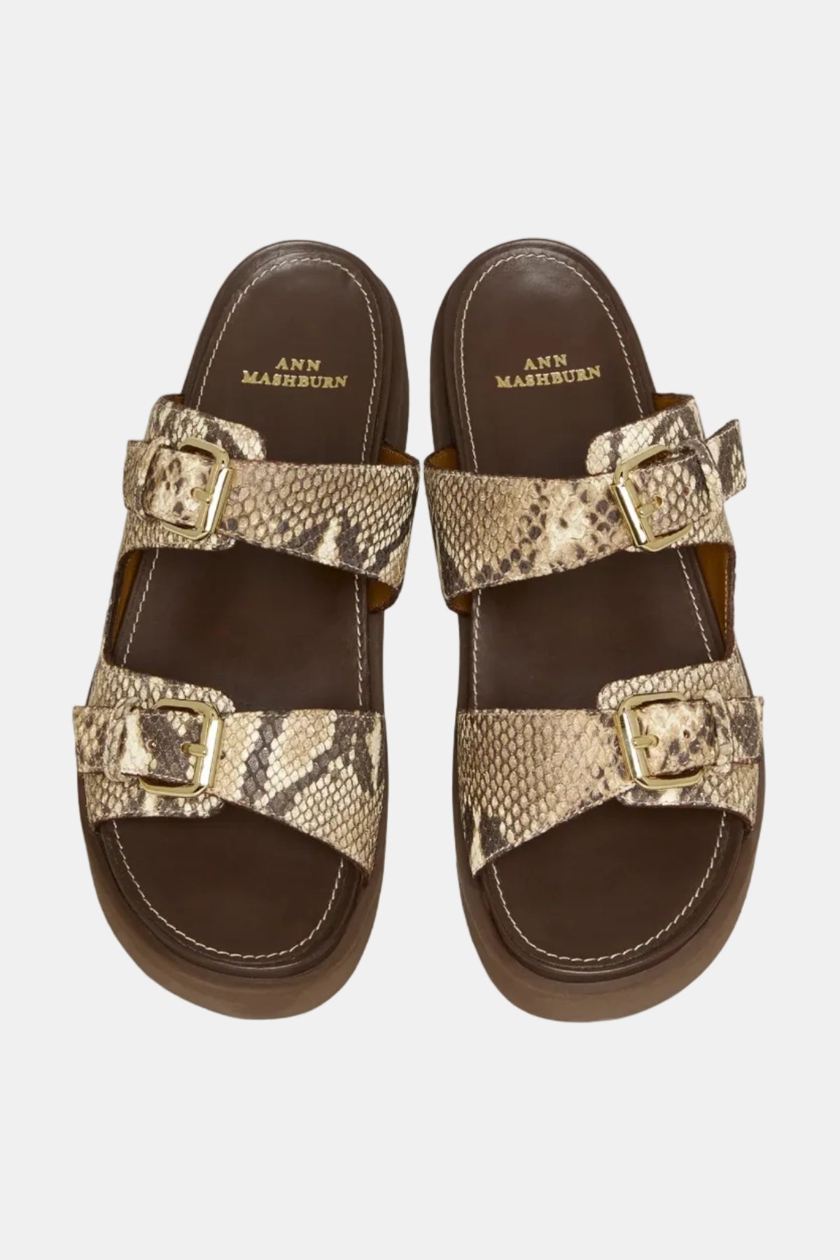 Pair of sandals with snake print straps on a light gray background