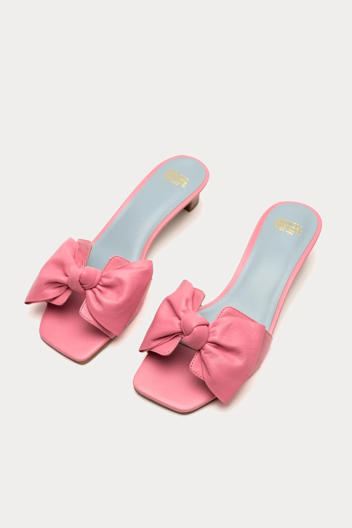 Pink sandals with large bows on a light gray background