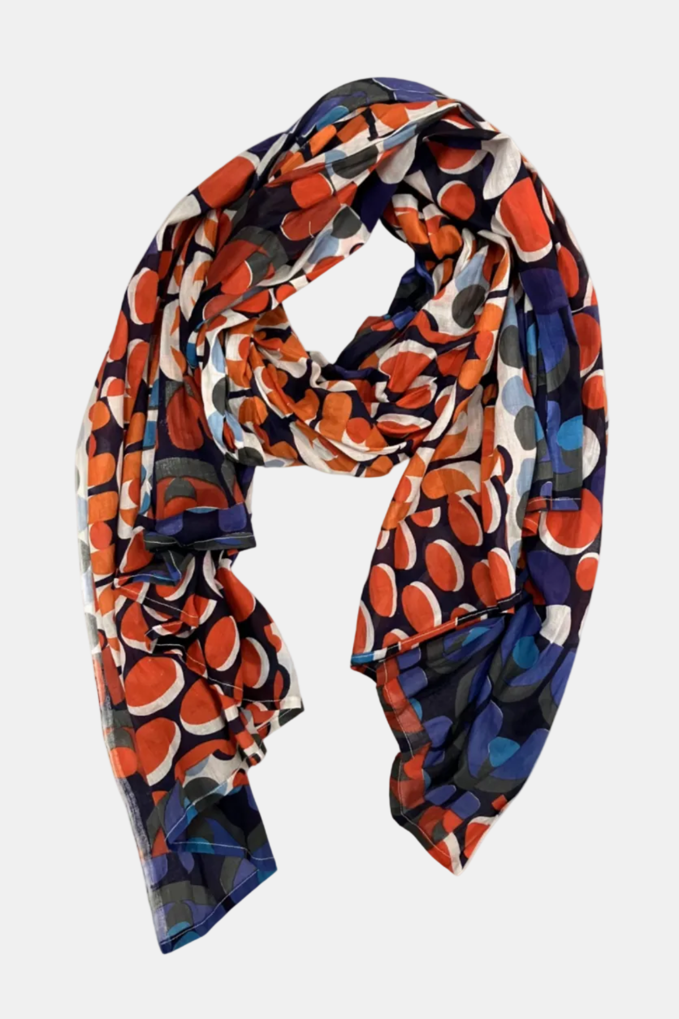 A lightweight scarf with an abstract, organic circular pattern in orange, blue, navy, gray, and white, draped against a solid white background.