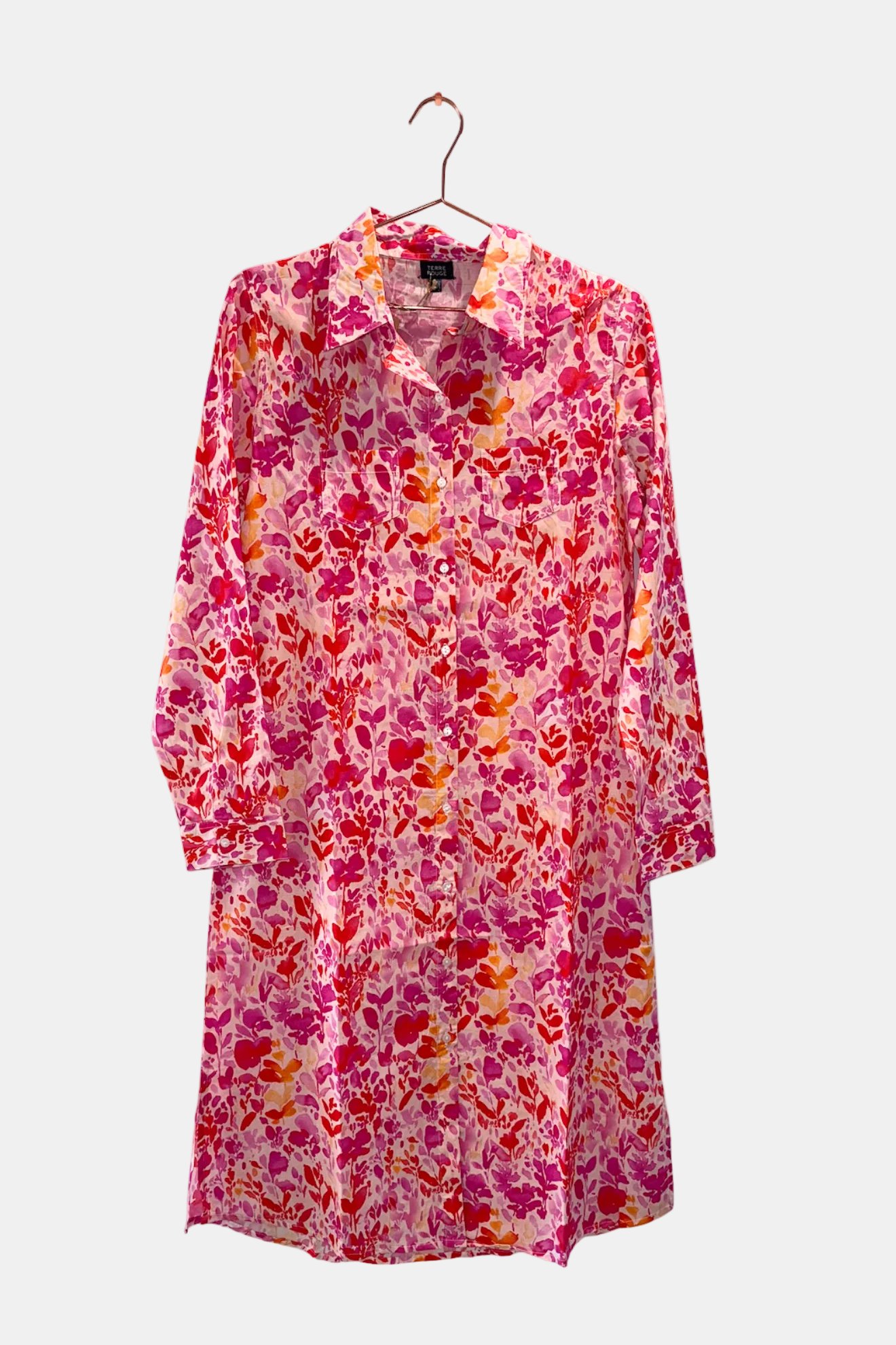 Floral patterned dress on a hanger against a white background