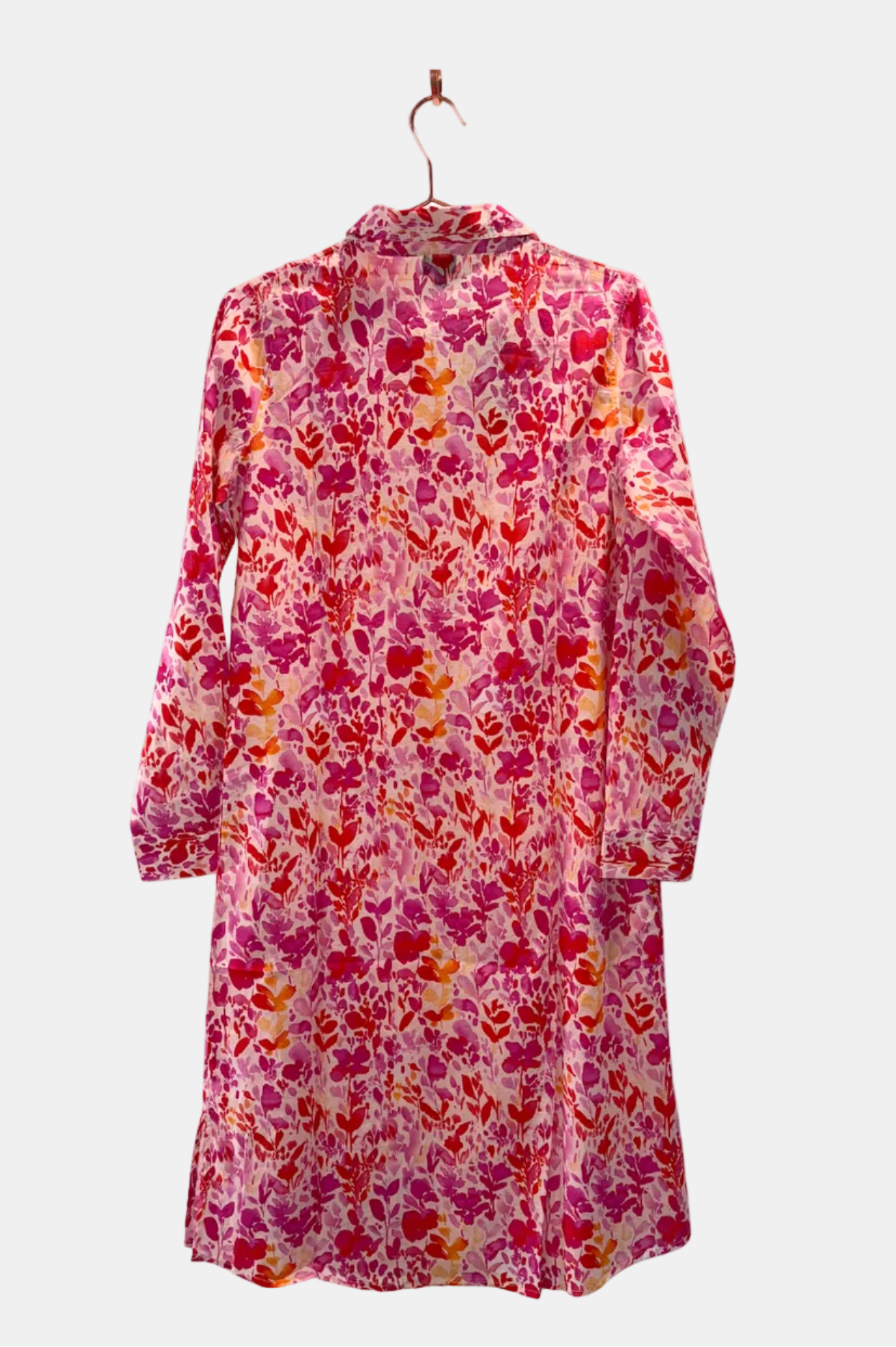 Floral patterned dress on a hanger against a white background