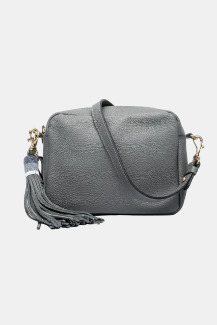 A brown leather handbag with a long shoulder strap, a tassel on the zipper, and a detachable shoulder strap.