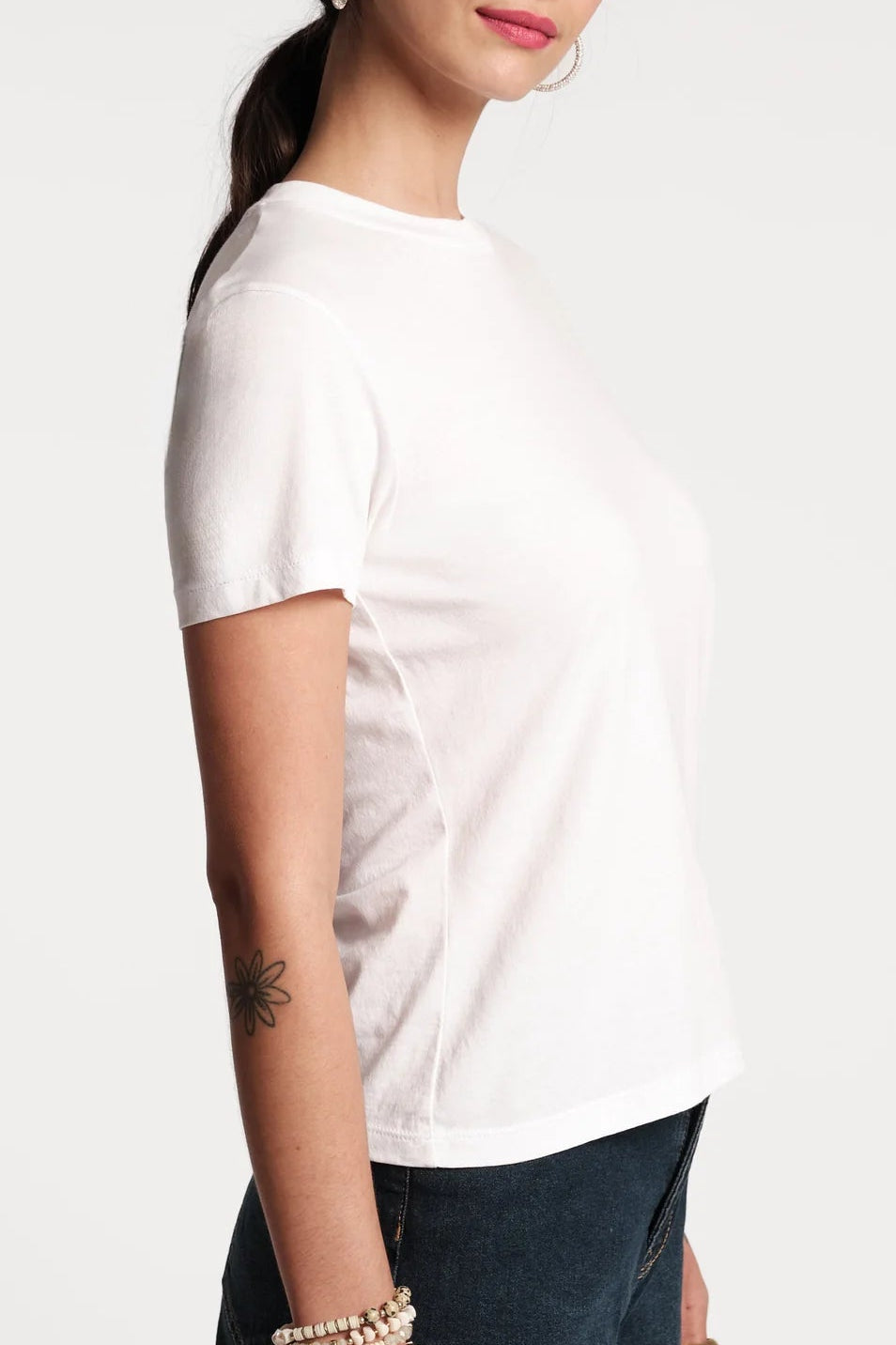Woman wearing a white t-shirt against a plain background