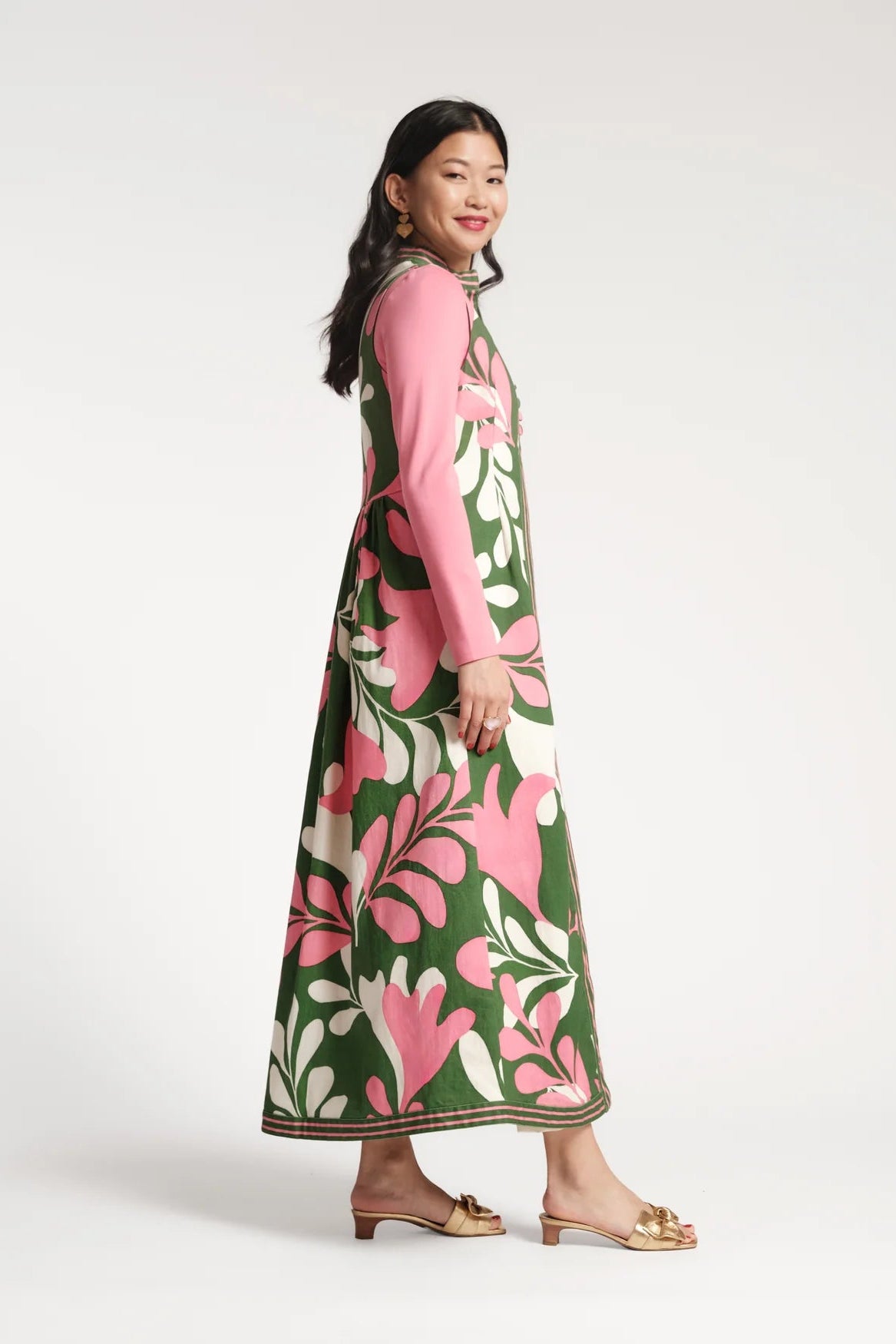 Woman wearing a pink and green floral dress on a white background