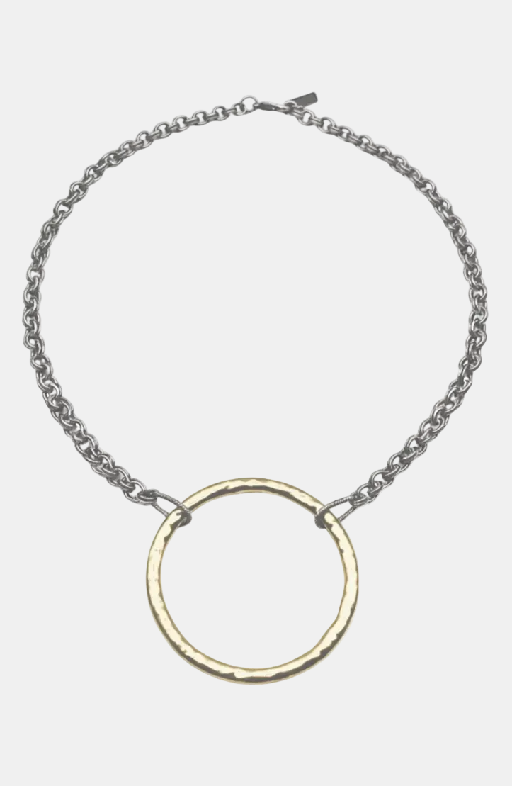 A silver chain necklace with a hammered gold-tone circular pendant, displayed on a clean white background.