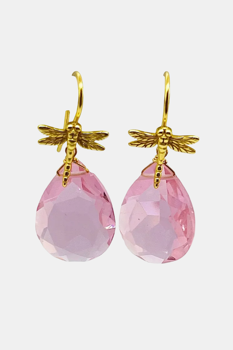 A pair of gold-tone dragonfly drop earrings with faceted light pink teardrop gemstones, shown against a plain white background.