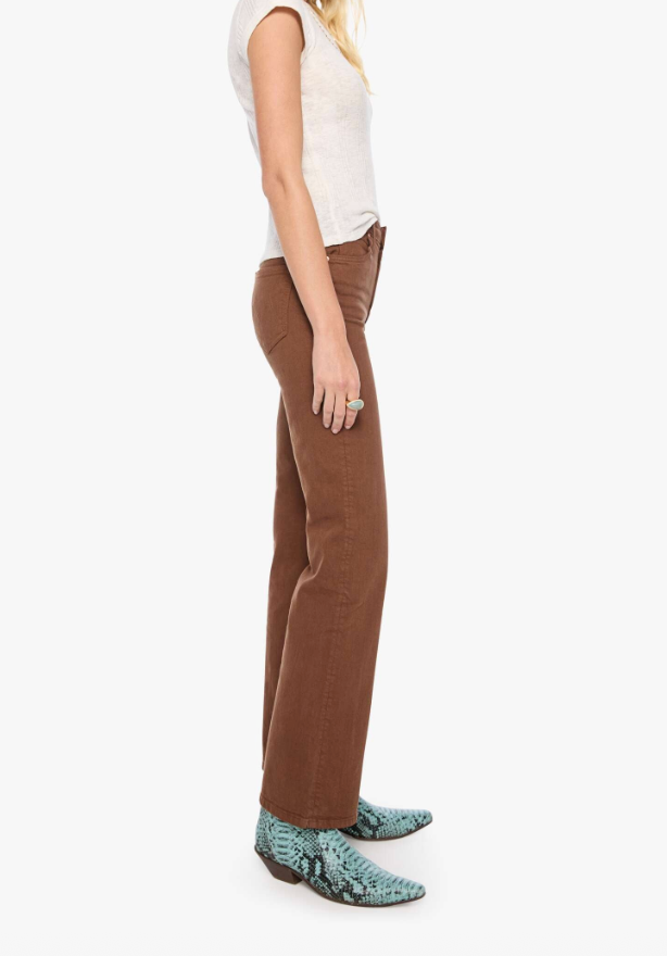 A side-profile view of a model wearing brown wide-leg pants, a white sleeveless top, and green snakeskin-patterned boots against a plain white background.