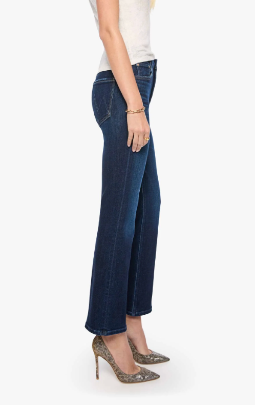 A side profile view of a model wearing dark blue wide-leg cropped jeans, a white sleeveless top, and leopard-print high heels against a plain white background.