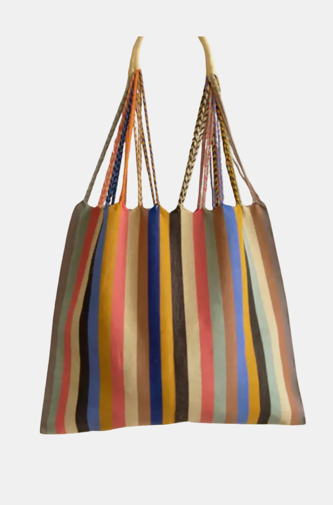 A large tote bag with vertical multicolor stripes in beige, brown, red, blue, yellow, and black, featuring two braided shoulder straps, shown against a plain white background.