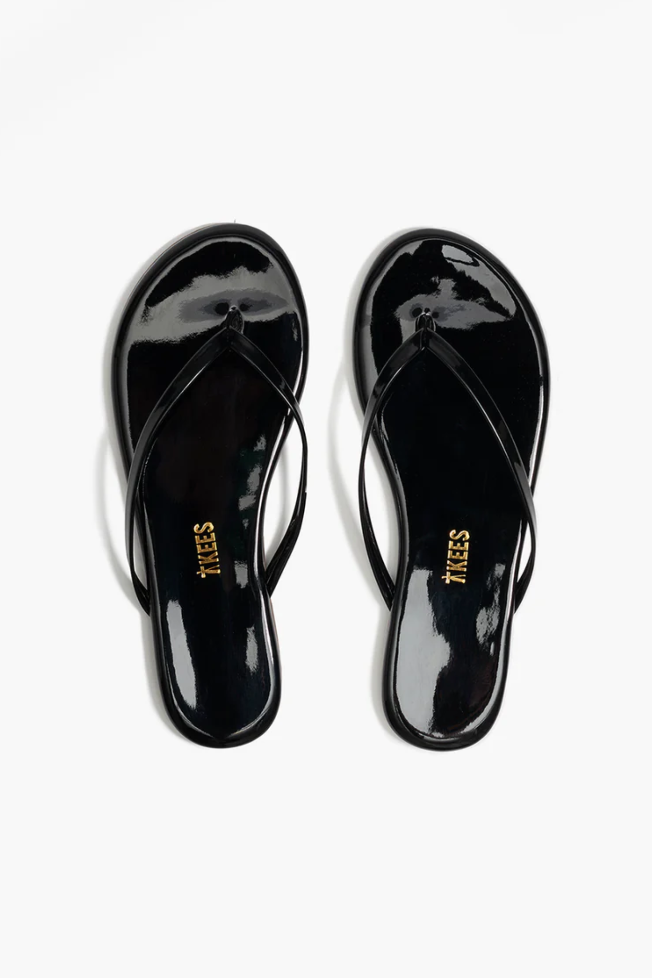 Black patent leather sandals on a white background