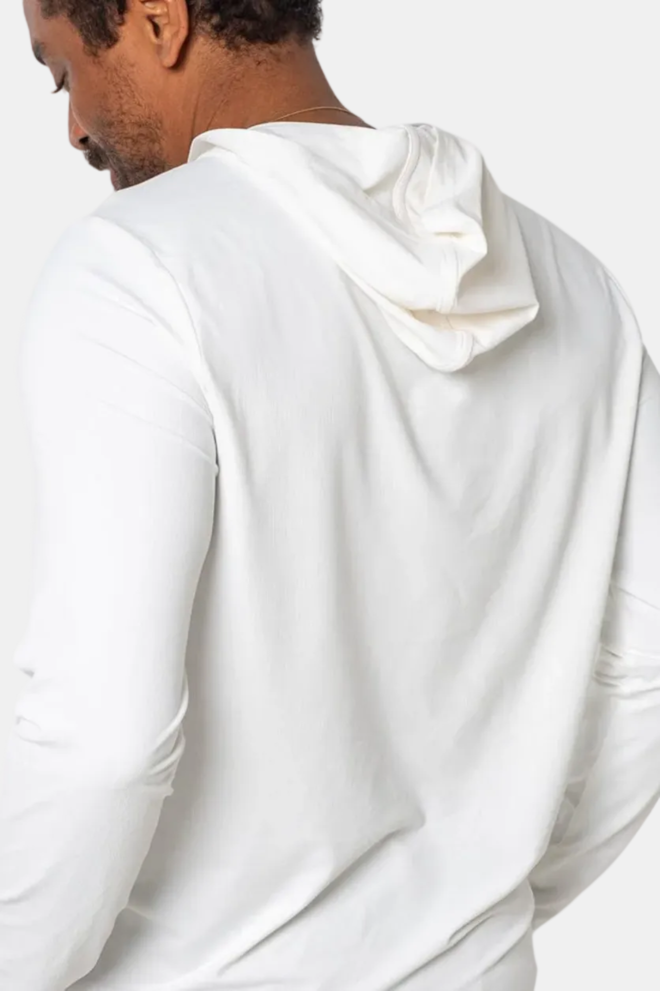 Person wearing a white hoodie from behind on a white background
