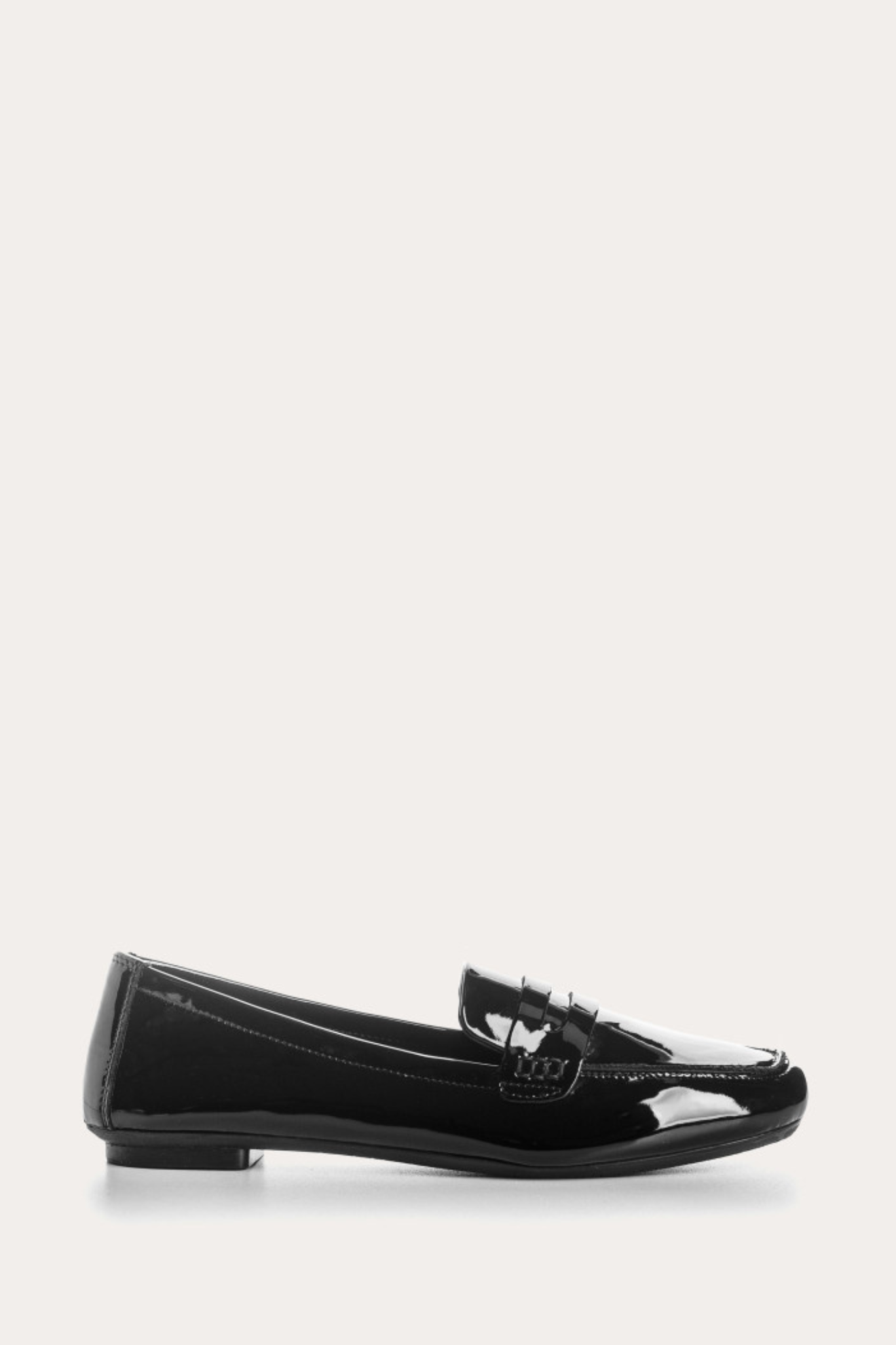 Black patent leather loafer on a white background