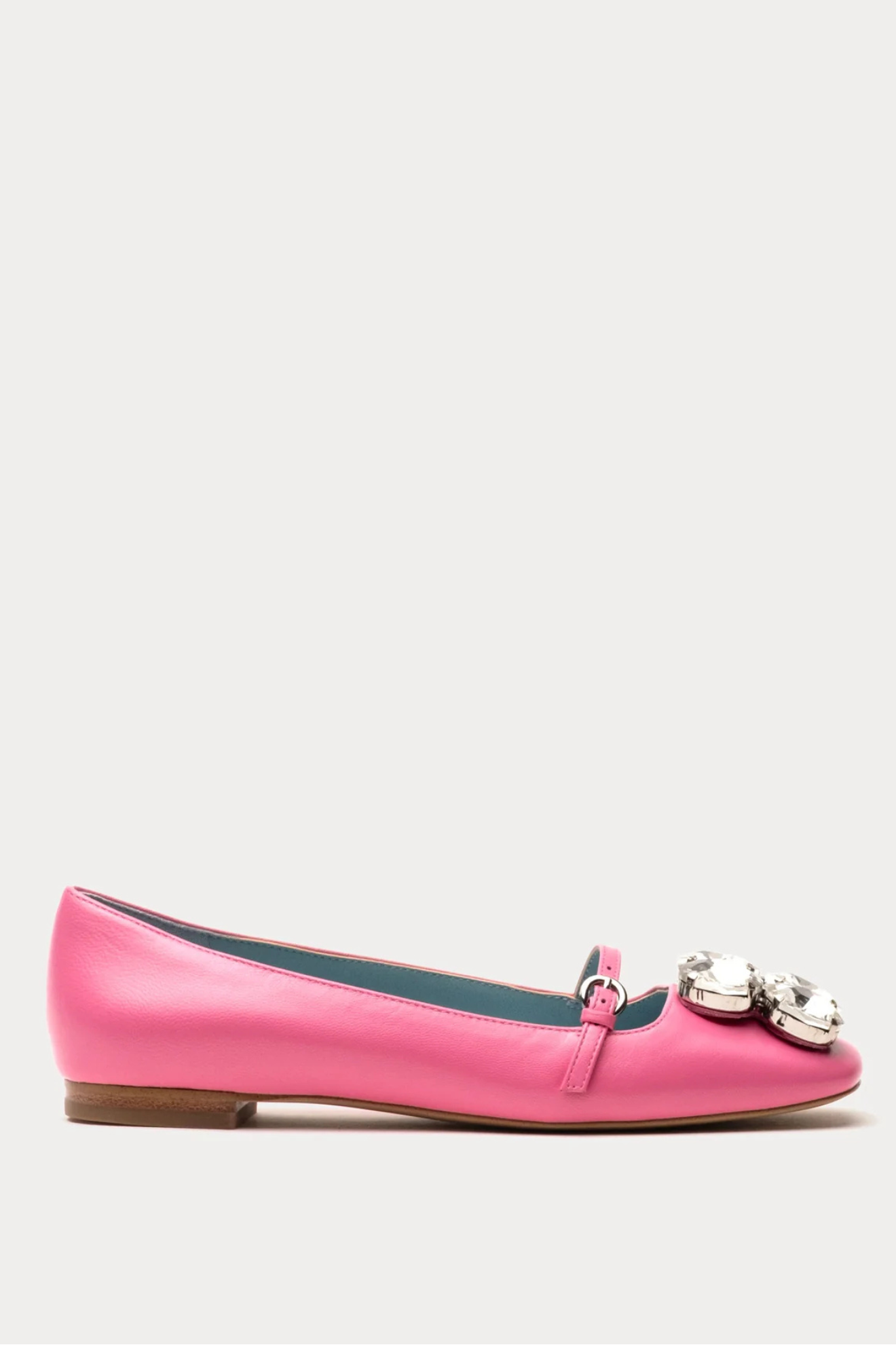 Pink flat shoe with decorative elements on a white background
