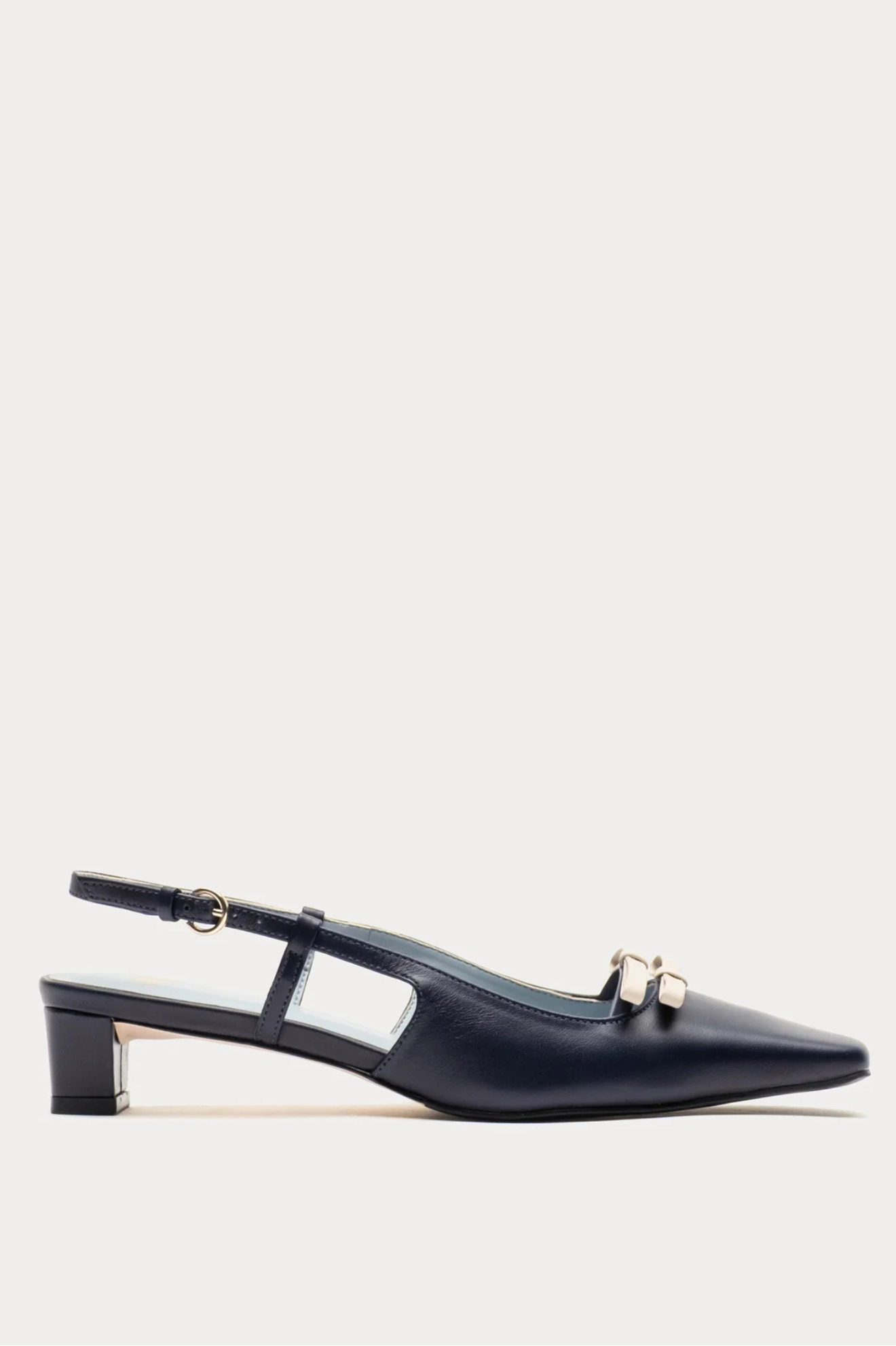 Black slingback shoes with a gold buckle on a white background