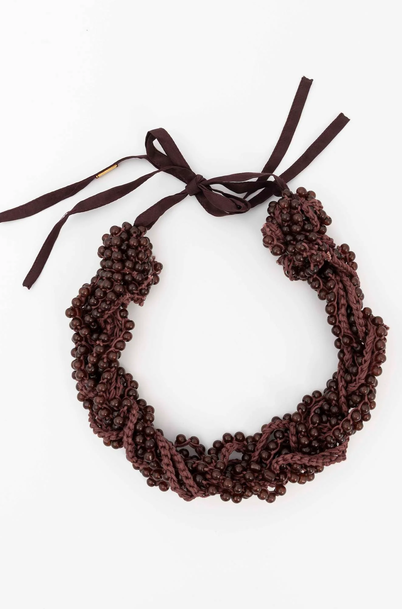 Brown beaded necklace with a bow on a white background
