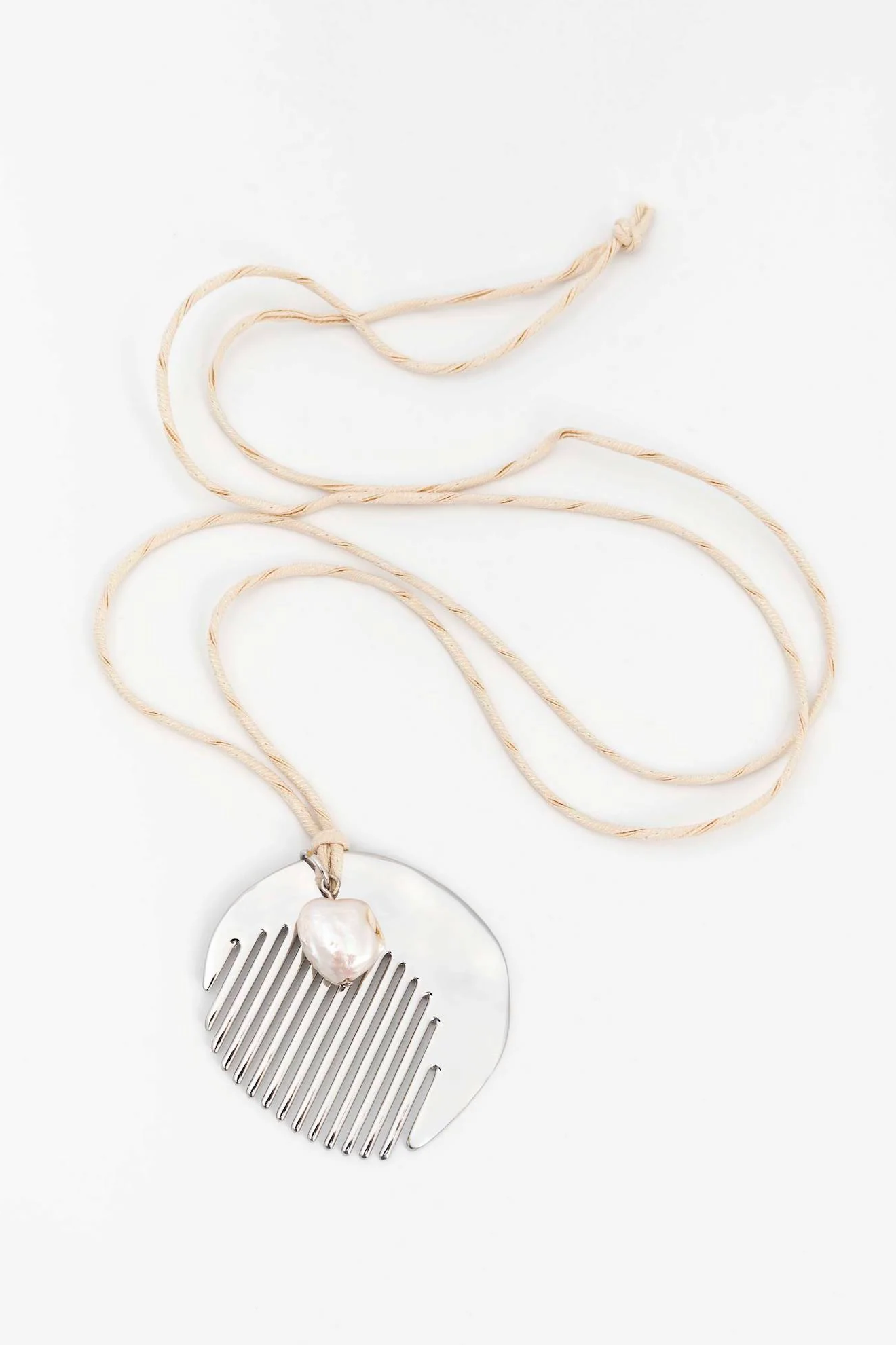 Necklace with a heart-shaped pendant and comb design on a white background