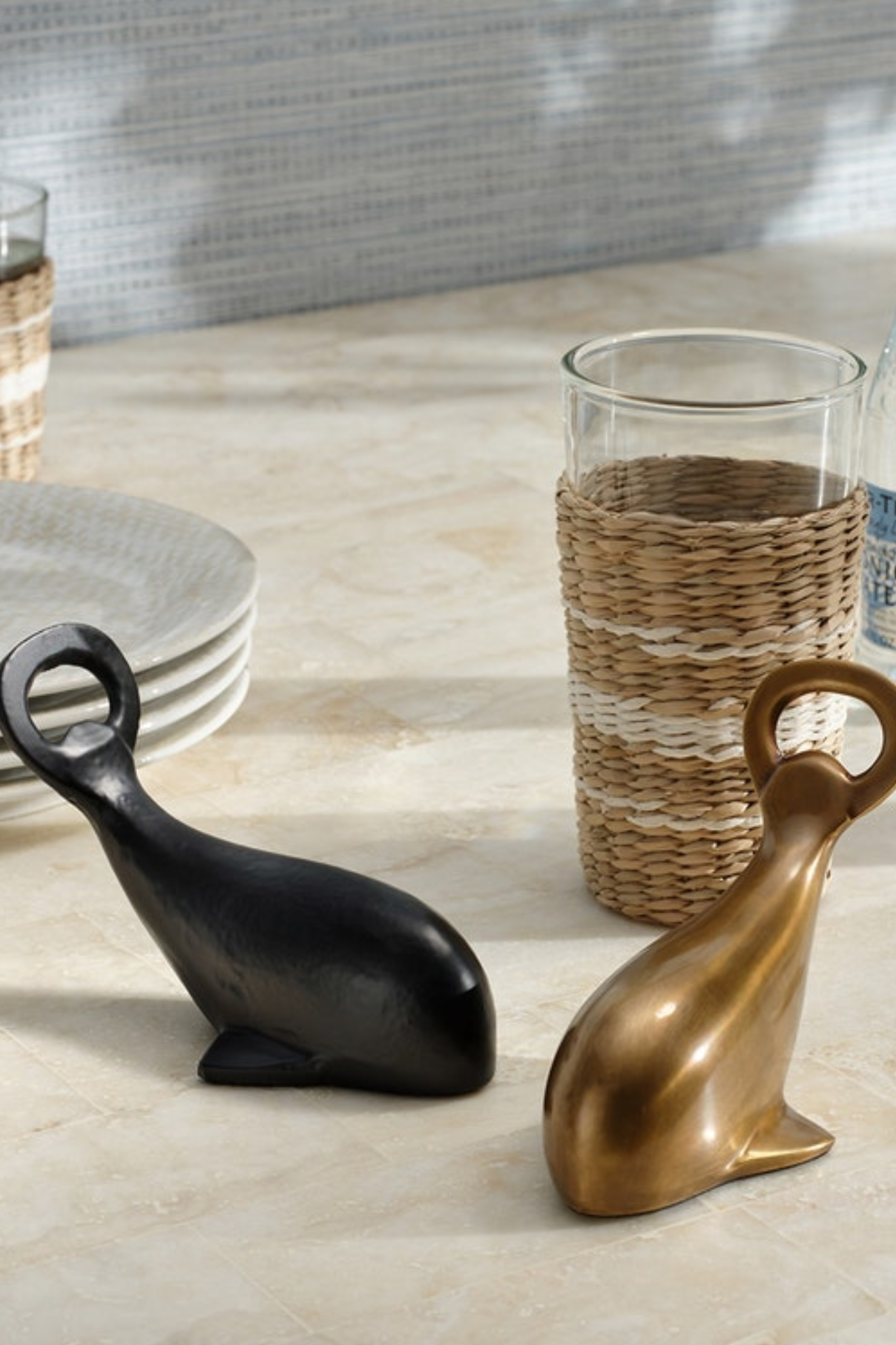 Decorative whale figurines in black and gold on a table with a neutral background