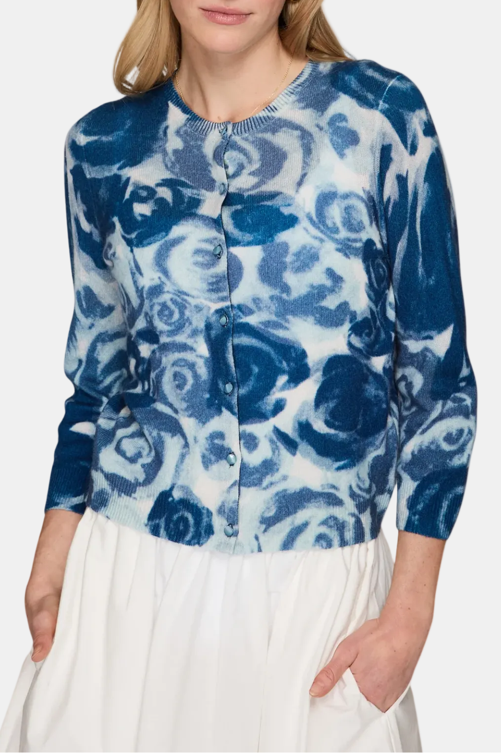 Woman wearing a blue floral patterned blouse against a white background
