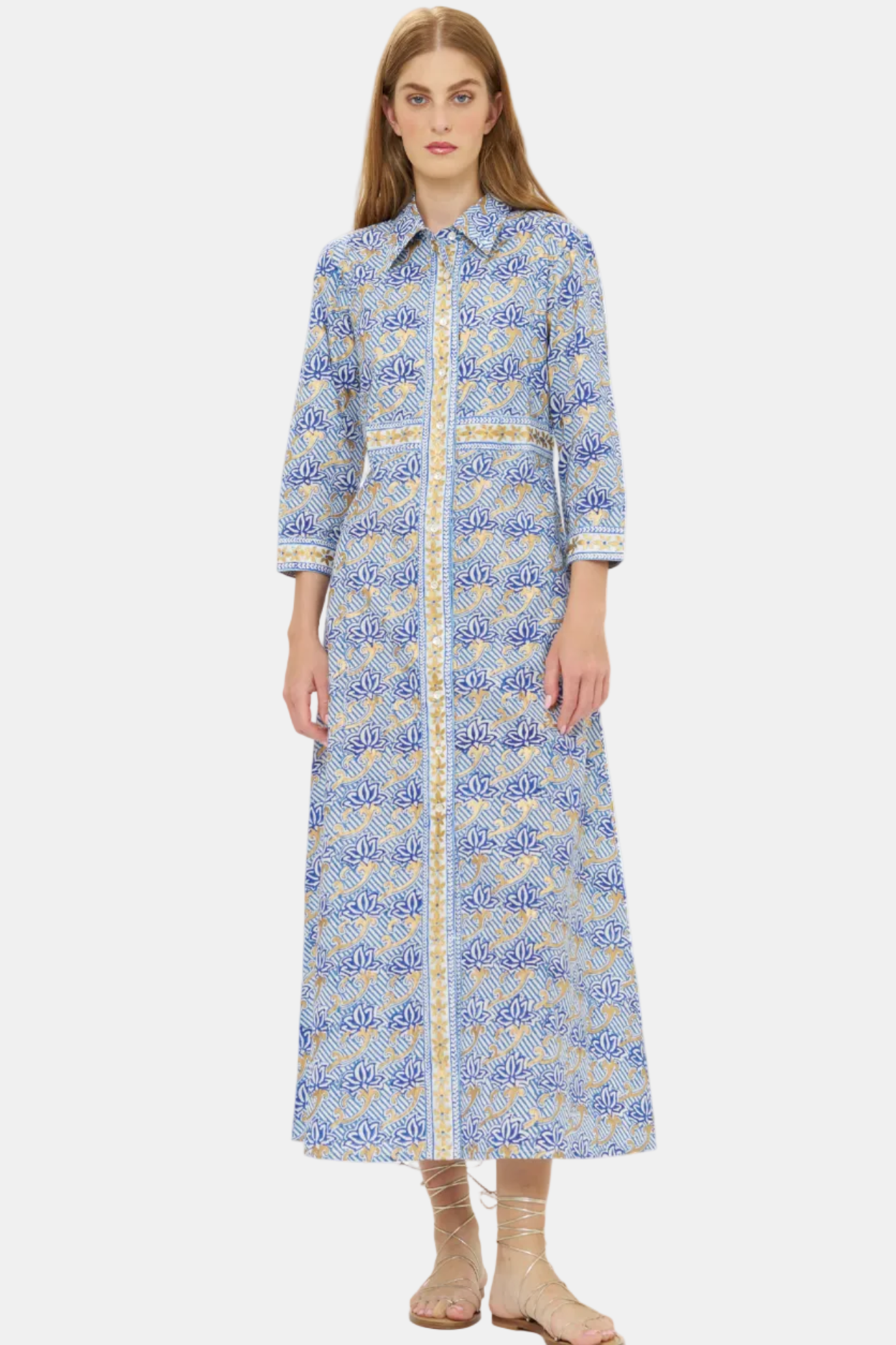 Woman wearing a long blue patterned dress on a white background