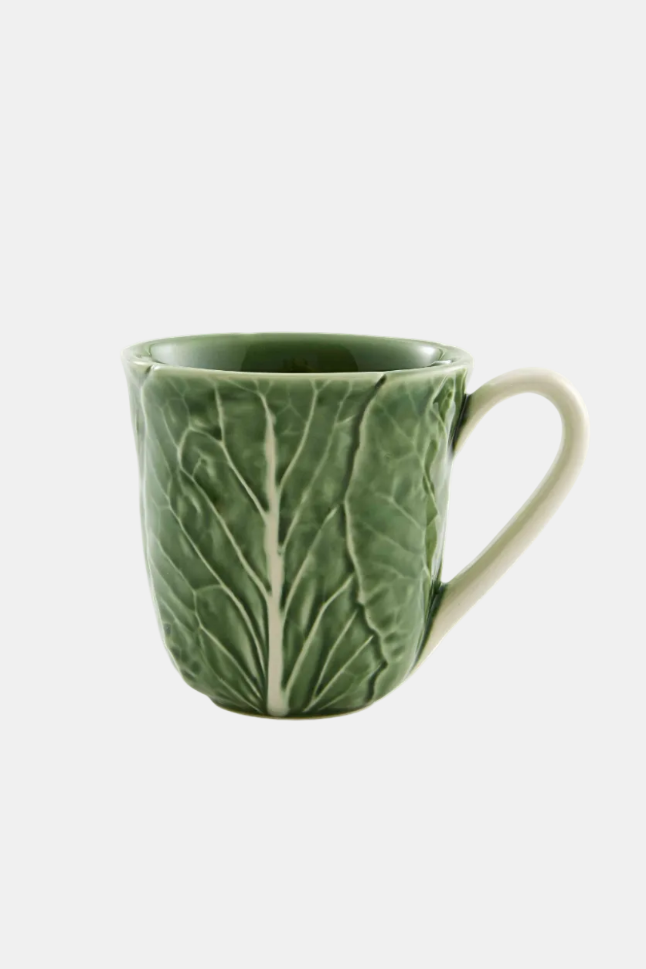 Green ceramic mug with leaf pattern on a white background