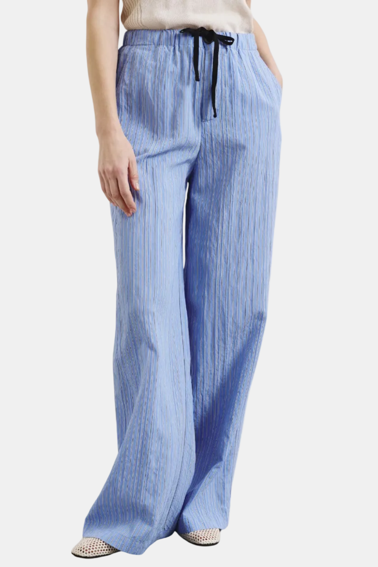 Blue striped pants worn by a person on a white background