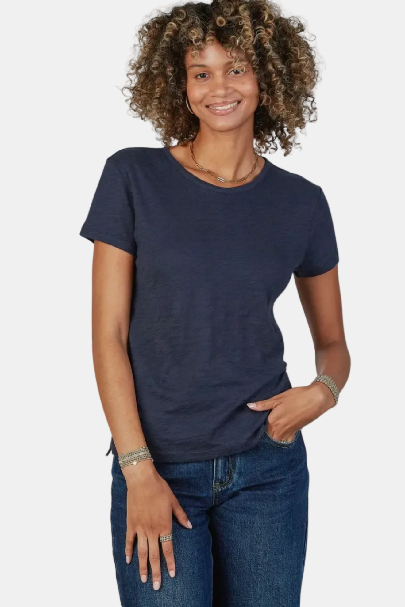 Woman wearing a navy blue t-shirt and jeans on a white background