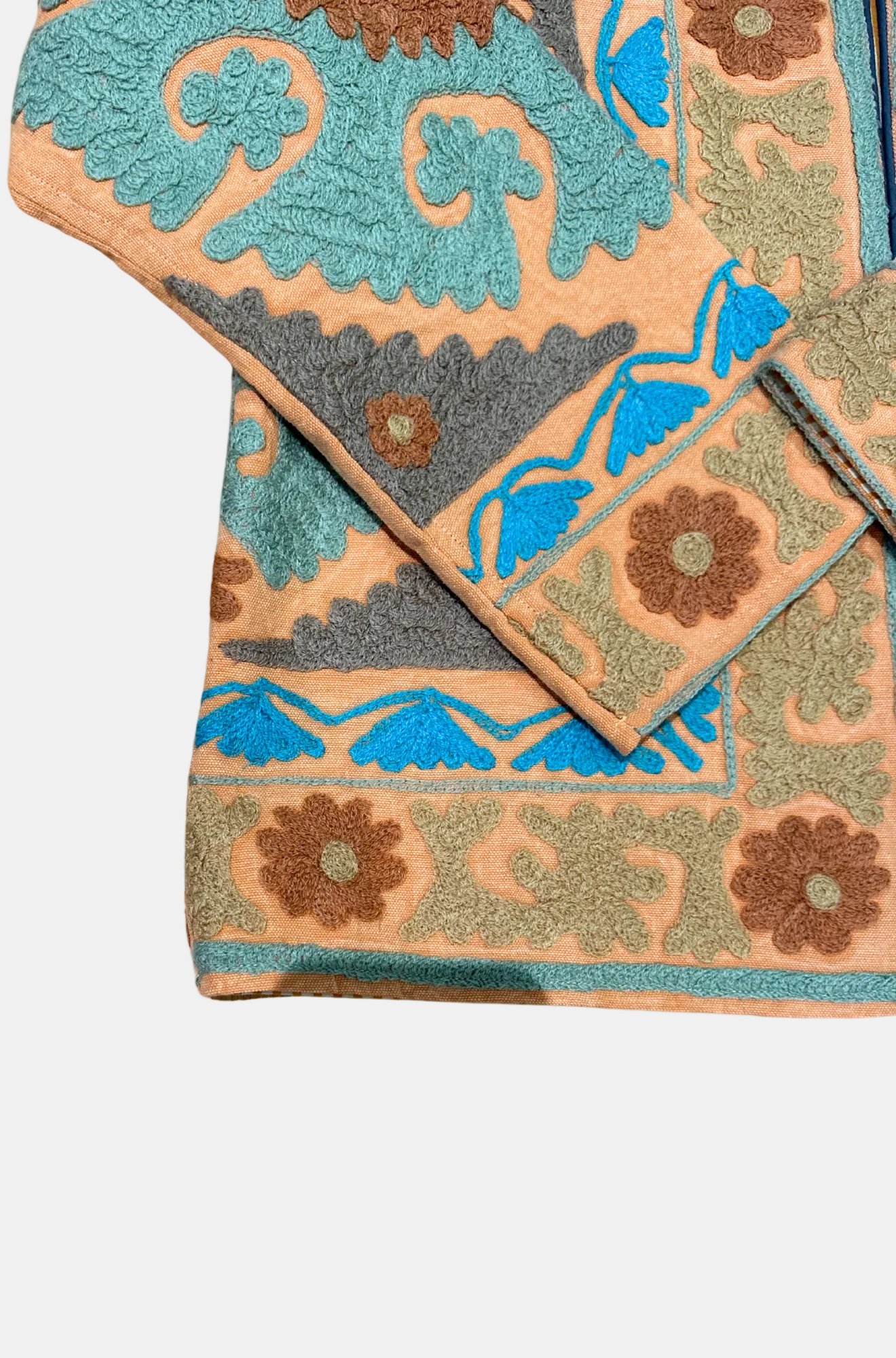 Decorative rug with intricate patterns in blue, brown, and beige on a white background