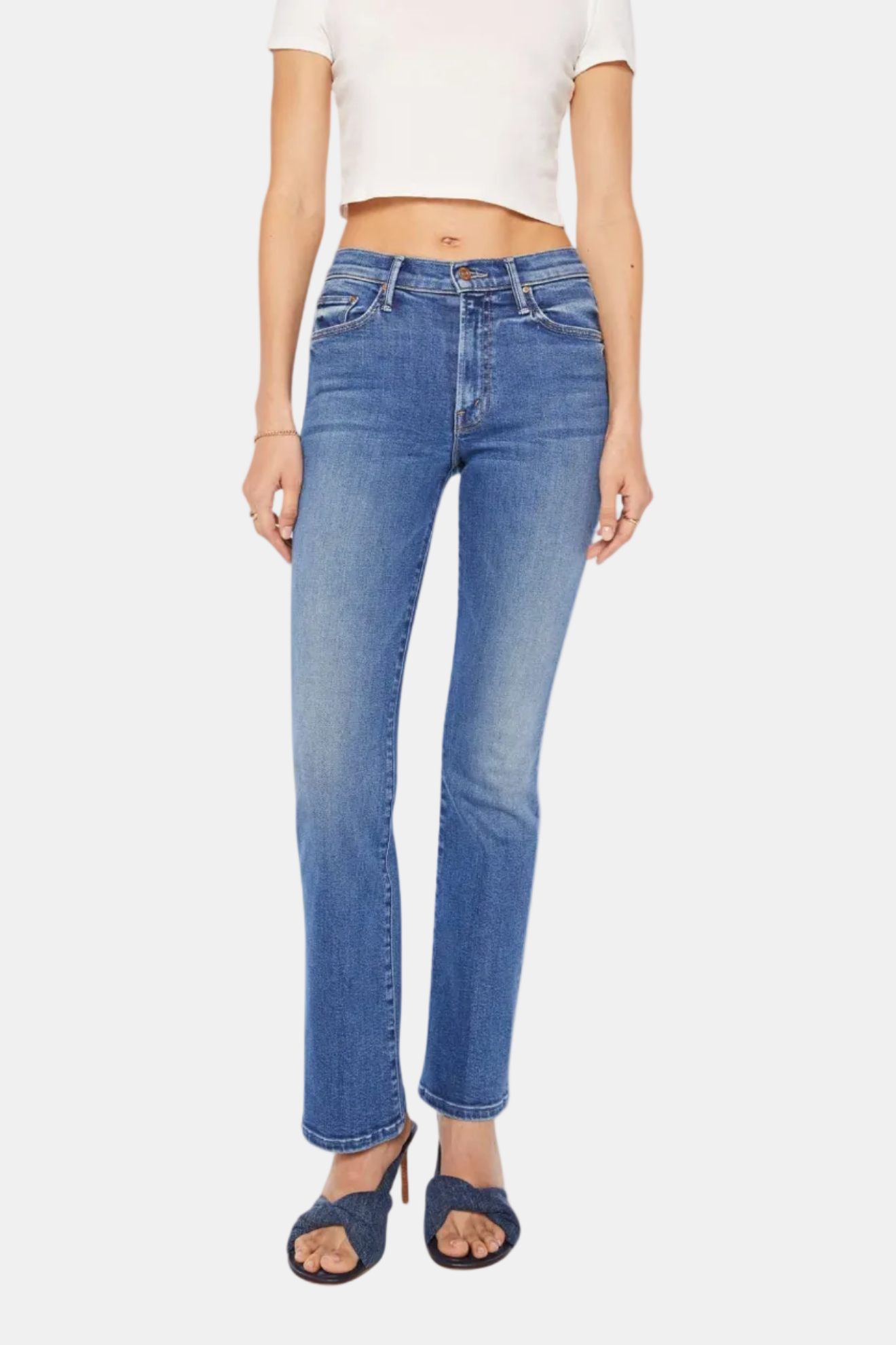 Person wearing blue jeans and a white top on a white background