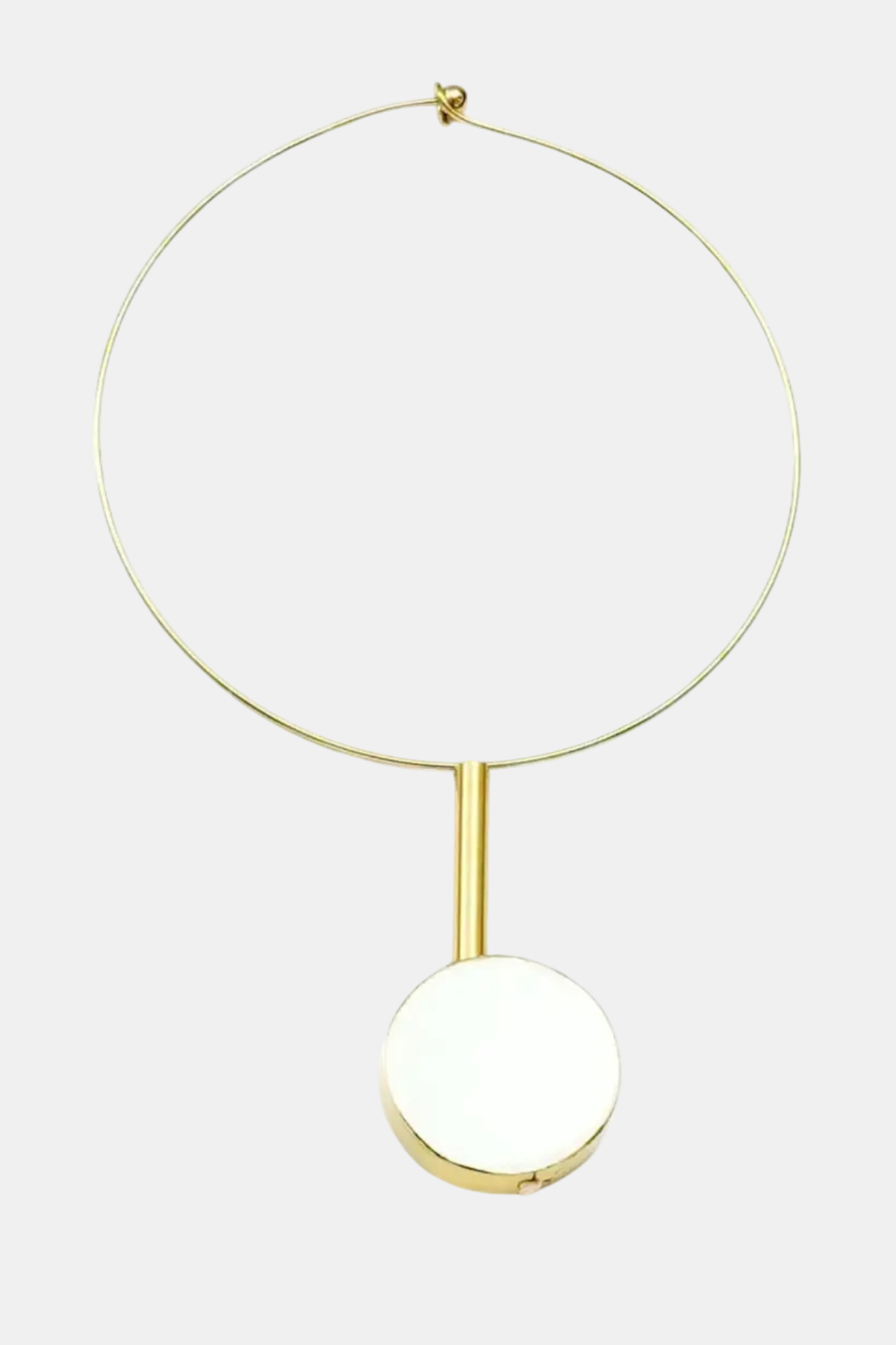 Necklace with a gold chain and white pendant on a white background