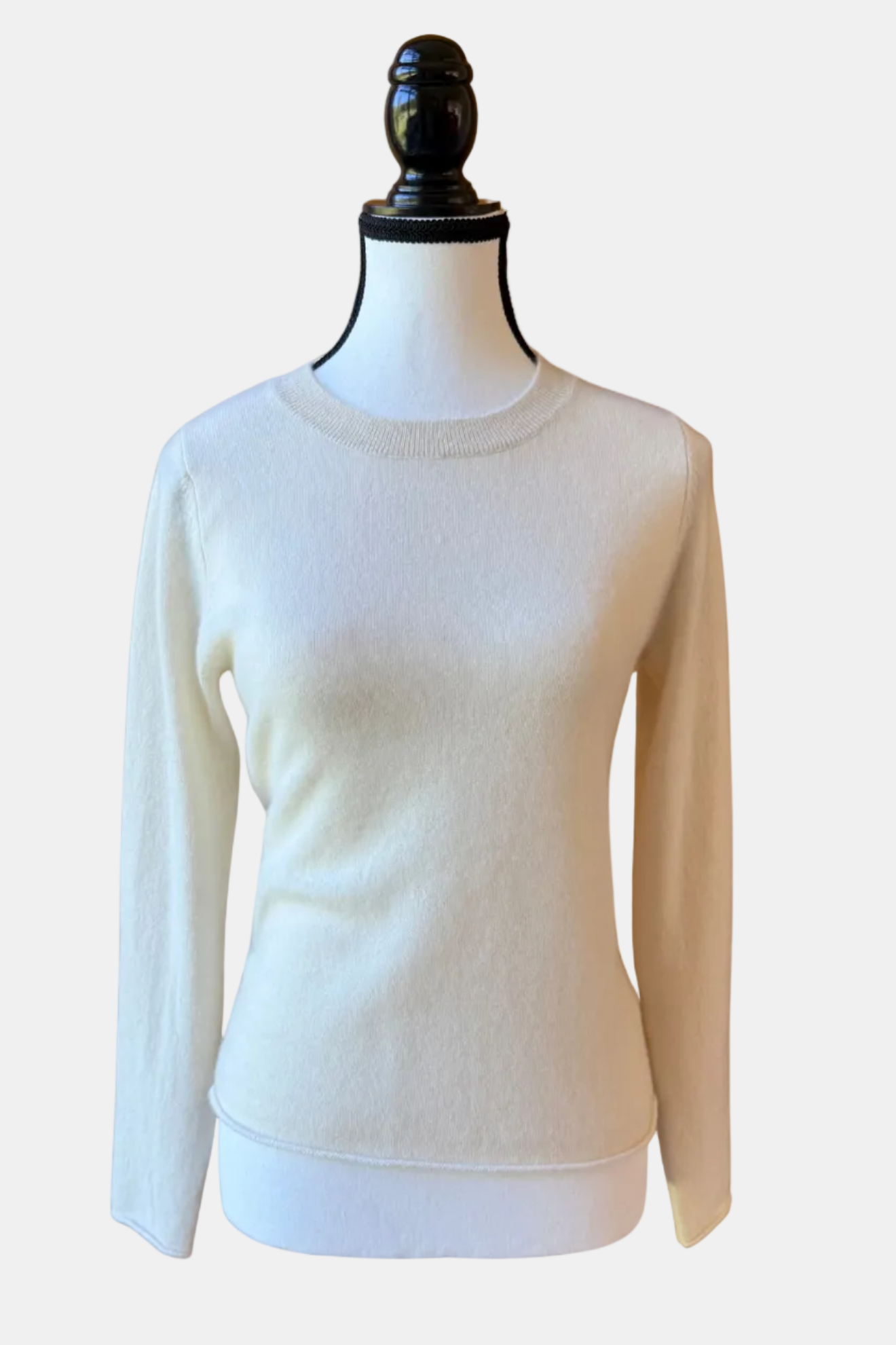 White sweater on a mannequin against a white background