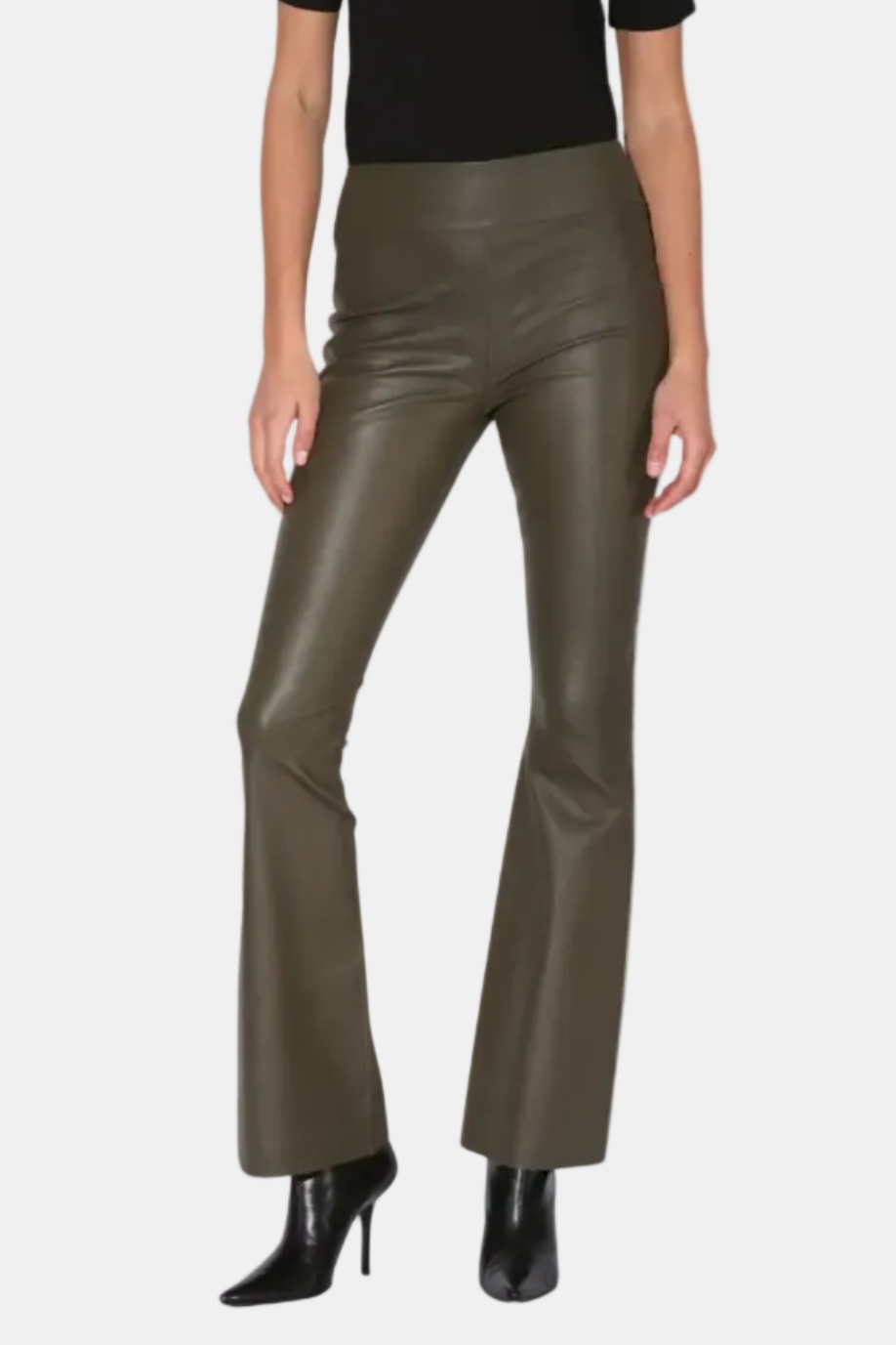 Woman wearing a black top and green leather pants on a white background