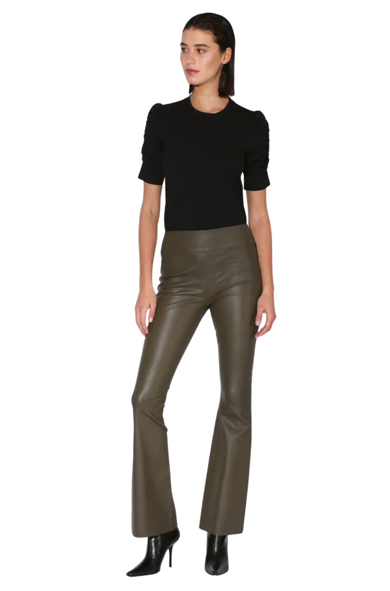 Woman wearing a black top and green leather pants on a white background