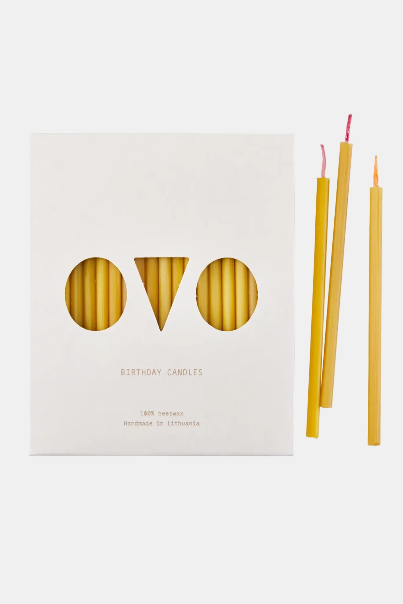 Beeswax candles with packaging on a white background
