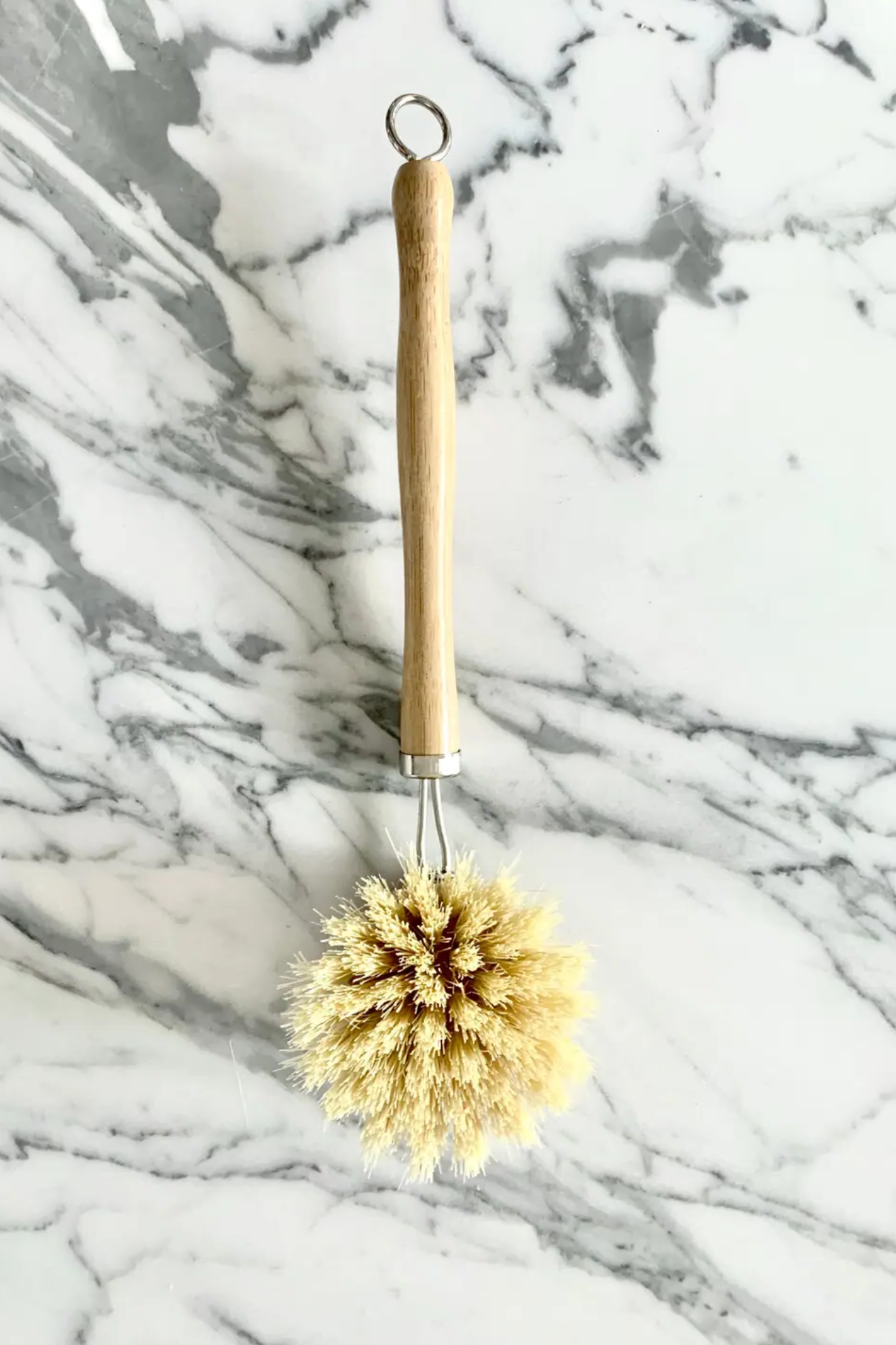 Bristle brush with wooden handle on a marble background