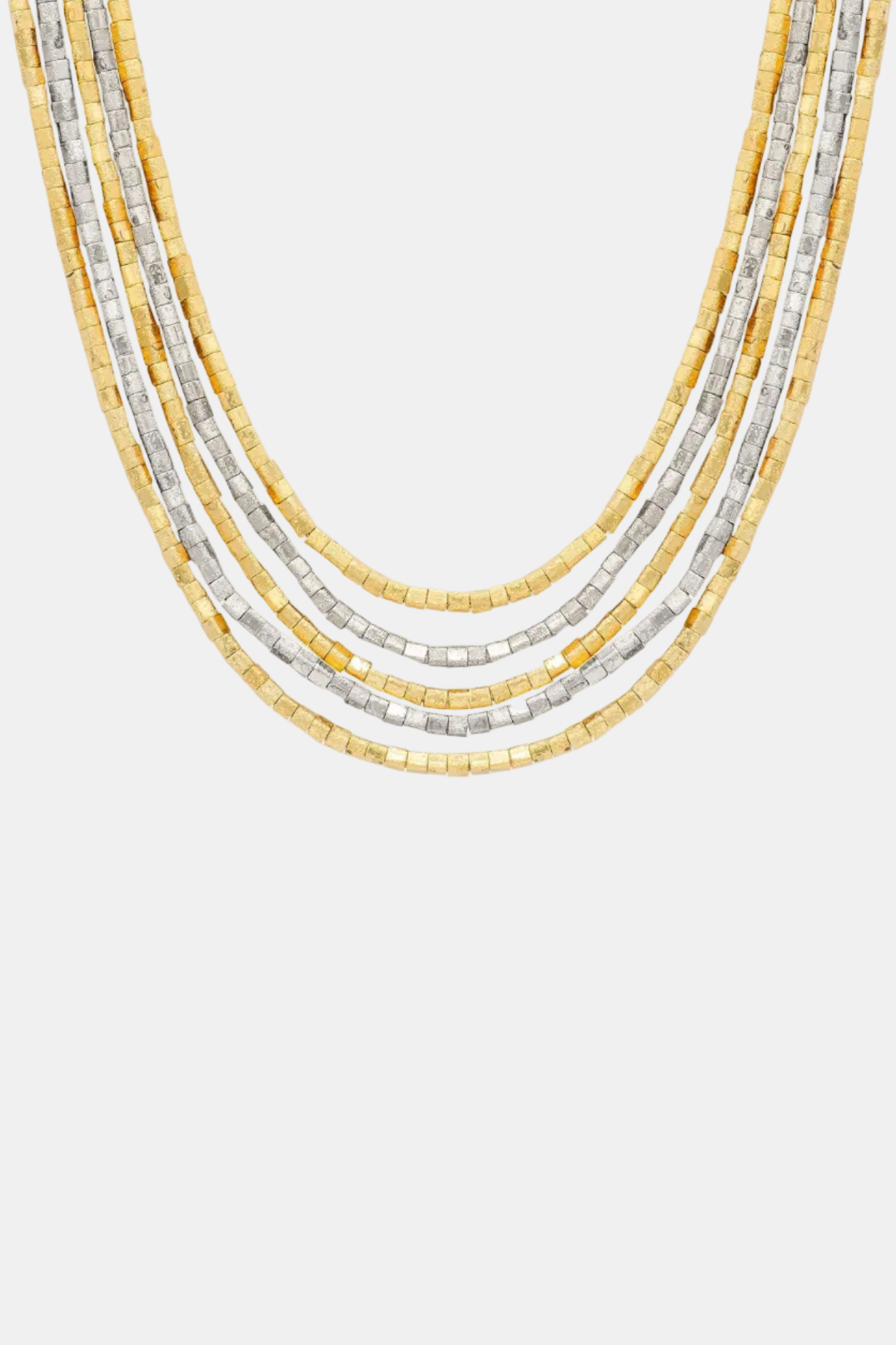 Stack of gold and silver beaded necklaces on a white background