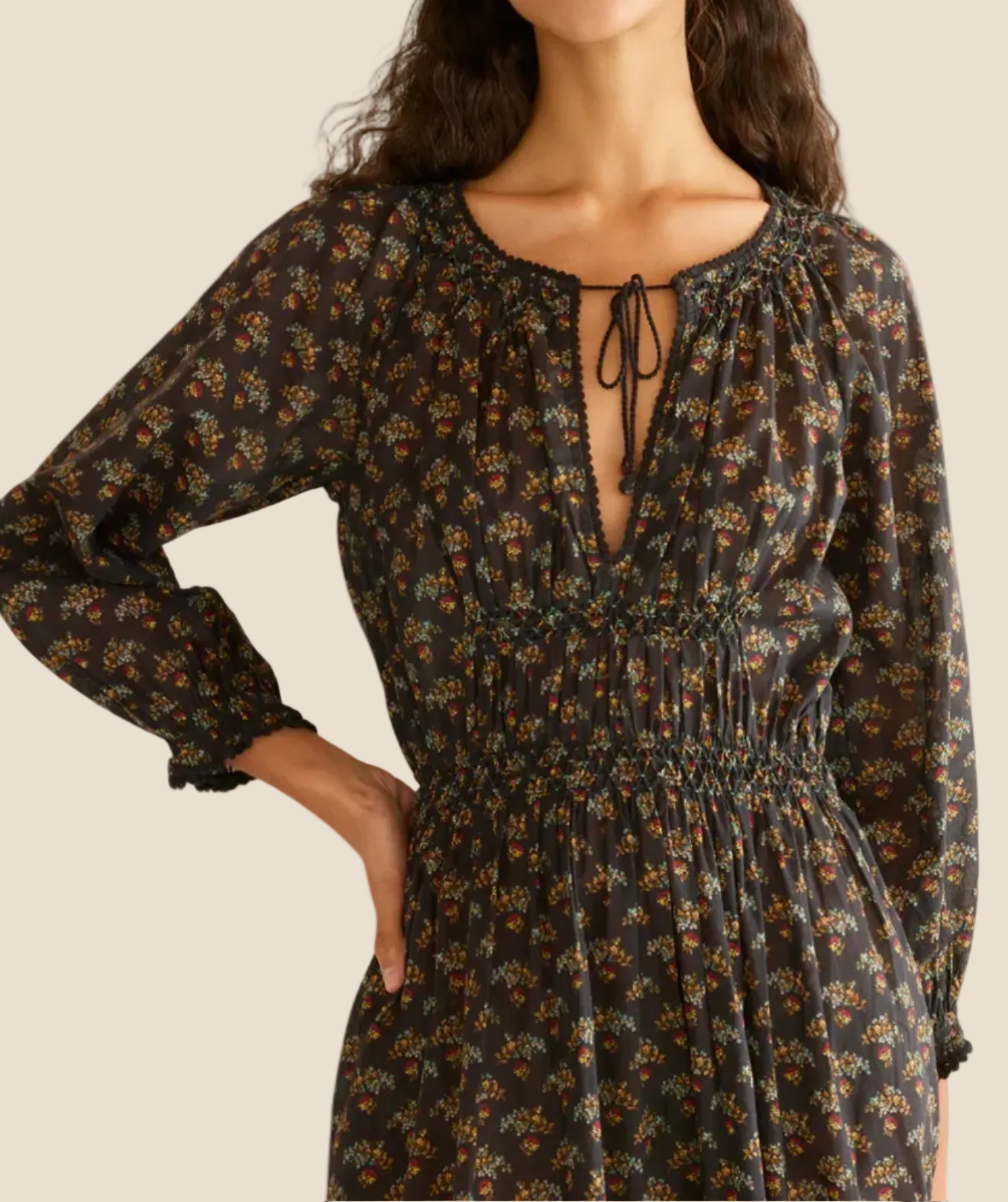 Woman wearing a floral dress with long sleeves on a white background