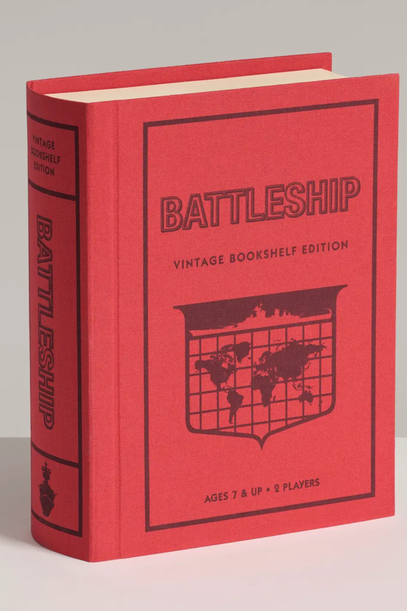 Red book-shaped Battleship game box with black text and world map design on a light gray background