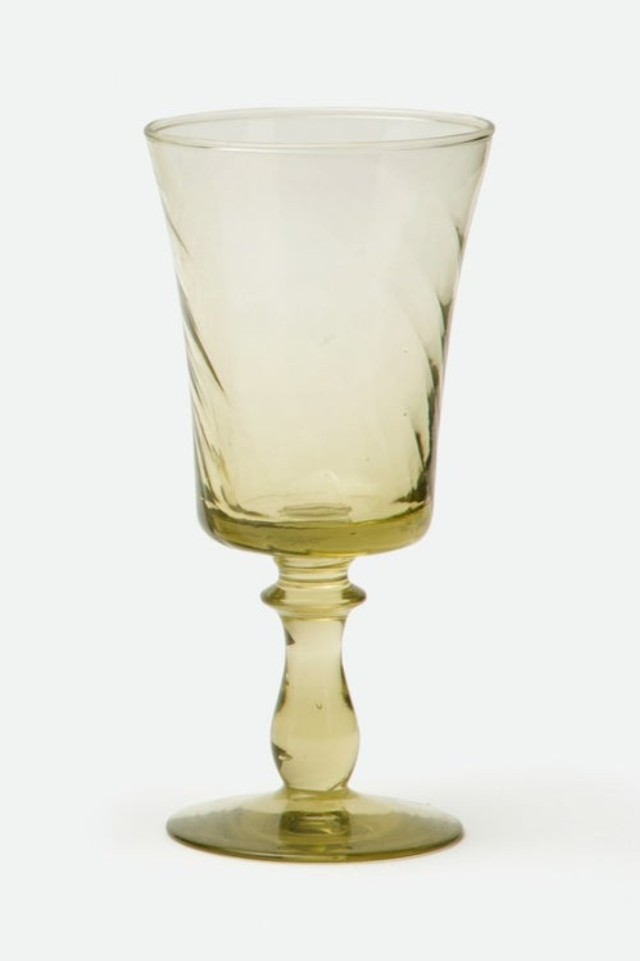 Yellow glass goblet on a white background