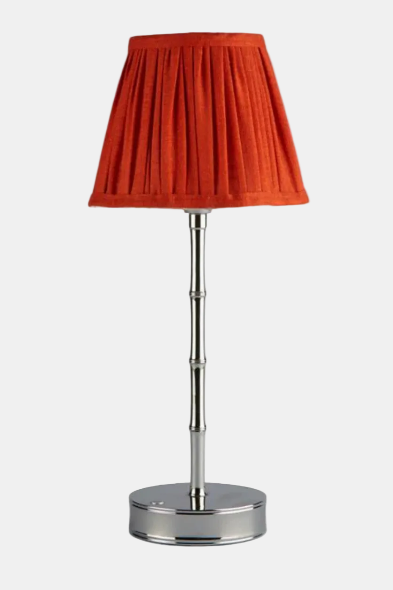 Table lamp with a red shade and silver base on a white background