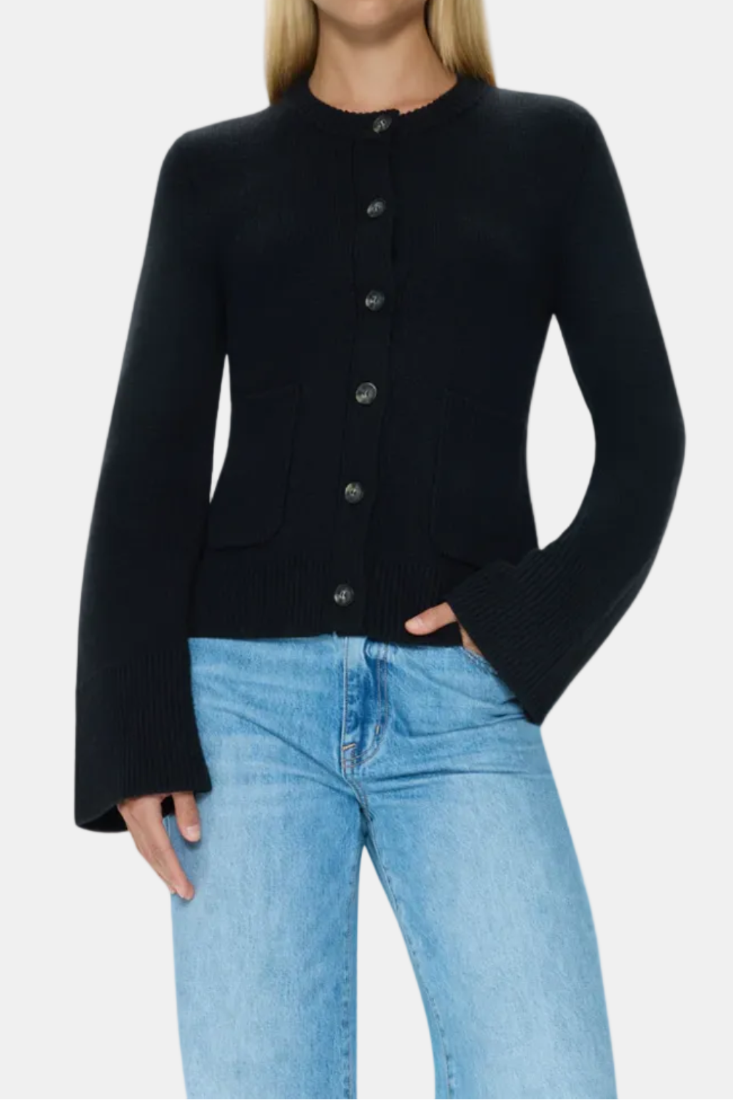 Woman wearing a black cardigan and light blue jeans on a white background