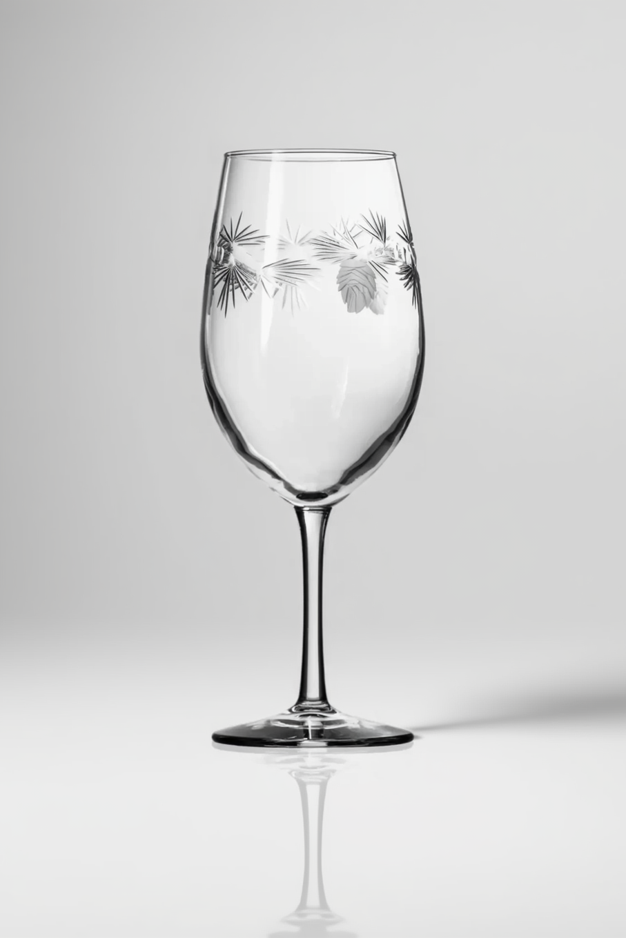 Clear wine glass with engraved design on a white background