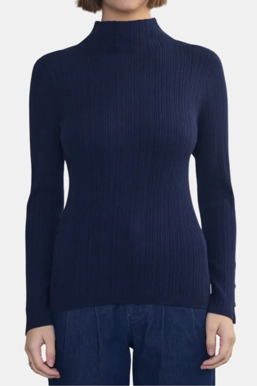 Woman wearing a navy blue ribbed turtleneck sweater on a white background