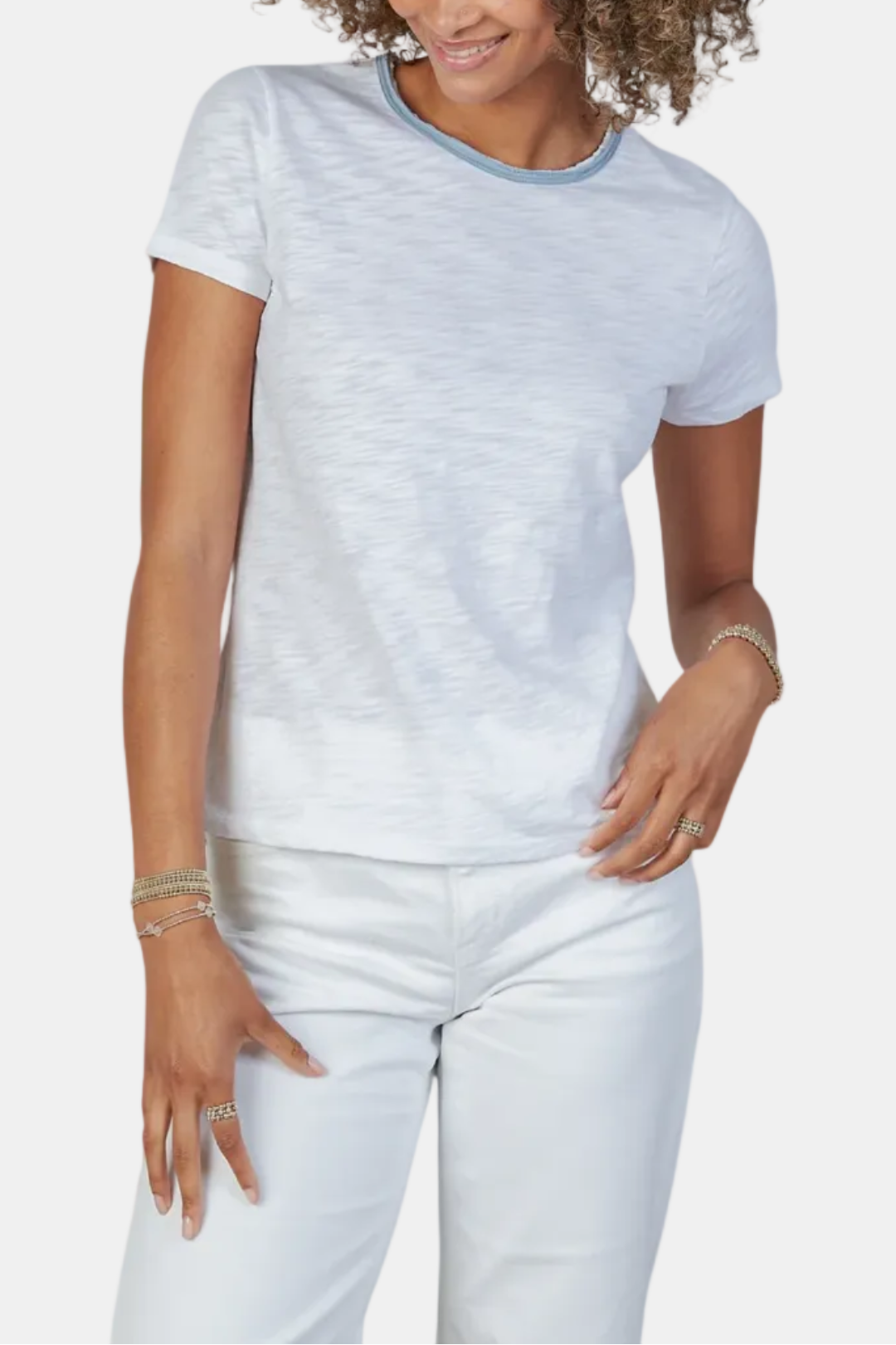Woman wearing a light gray t-shirt and white pants on a white background