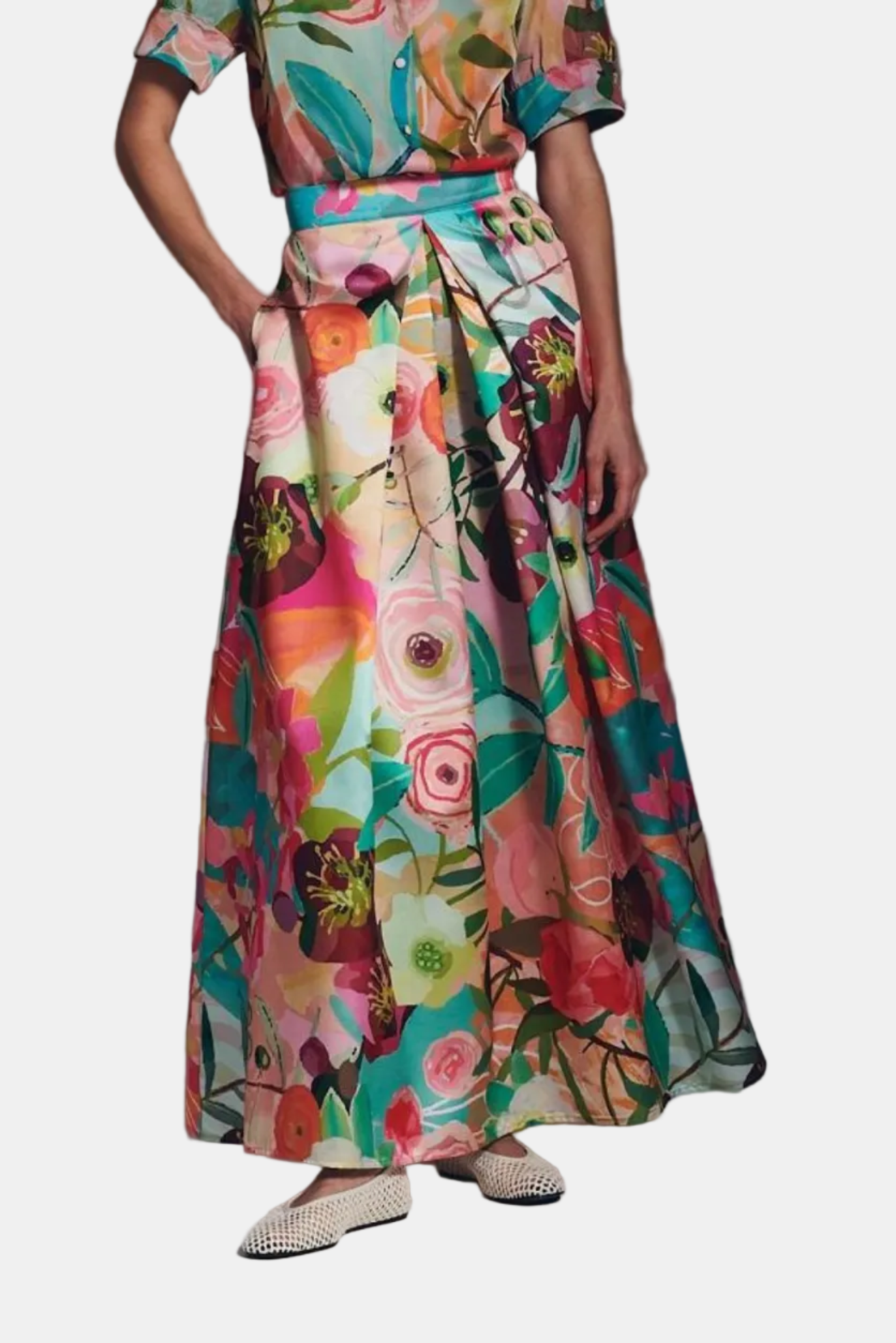 Person wearing a colorful floral dress on a gray background
