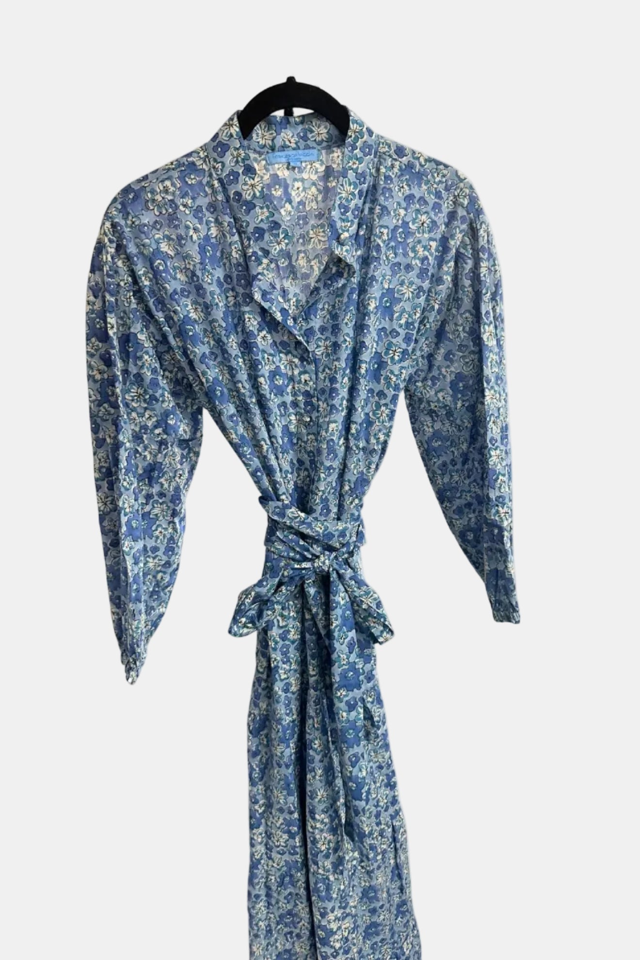 Blue floral patterned dress on a hanger against a white background